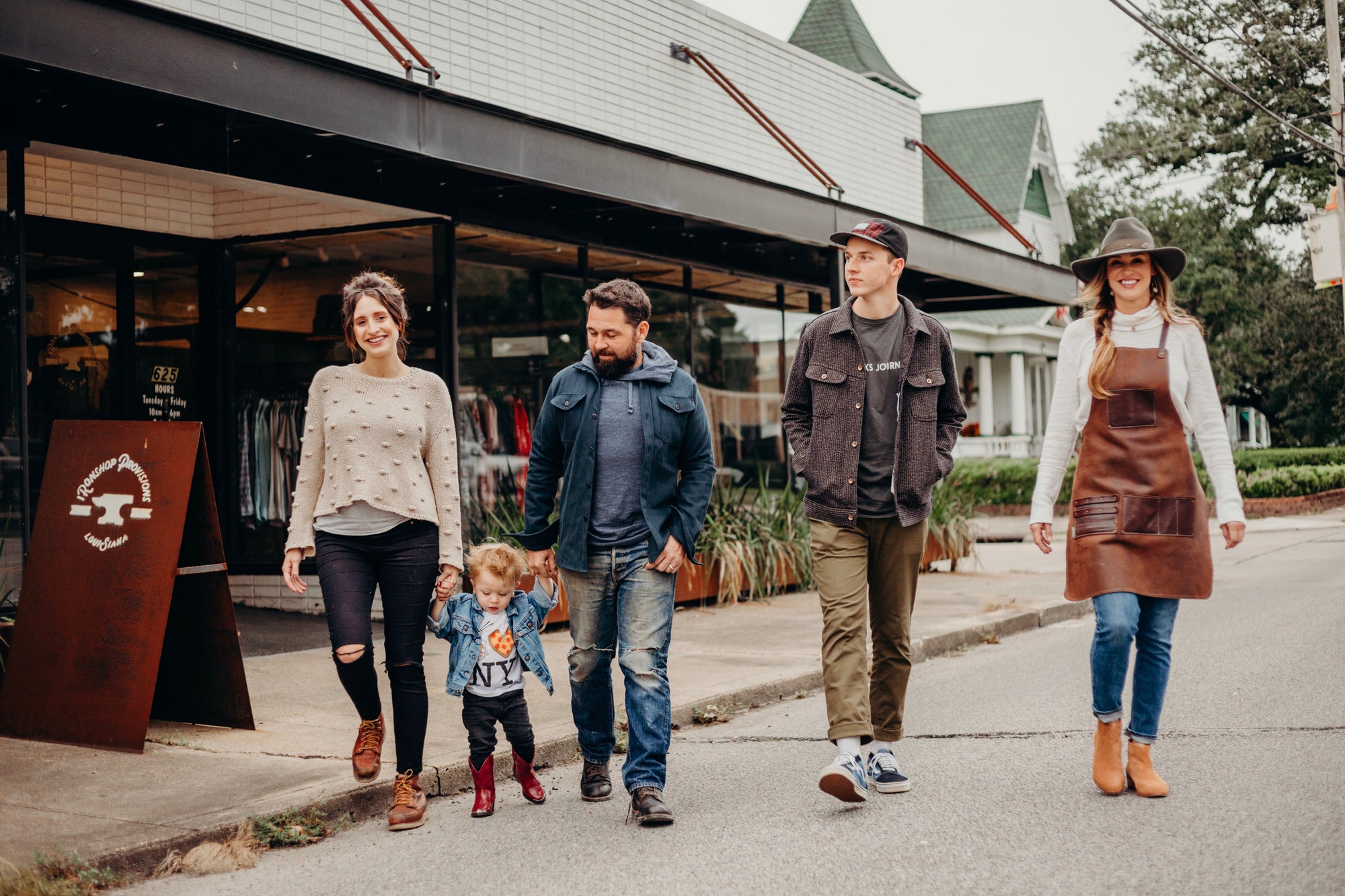 Family and friends walking outside Iron Shop Provisions store on a casual day