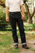 Man outdoors wearing dark indigo wide taper jeans cuffed, white t-shirt, and brown leather boots