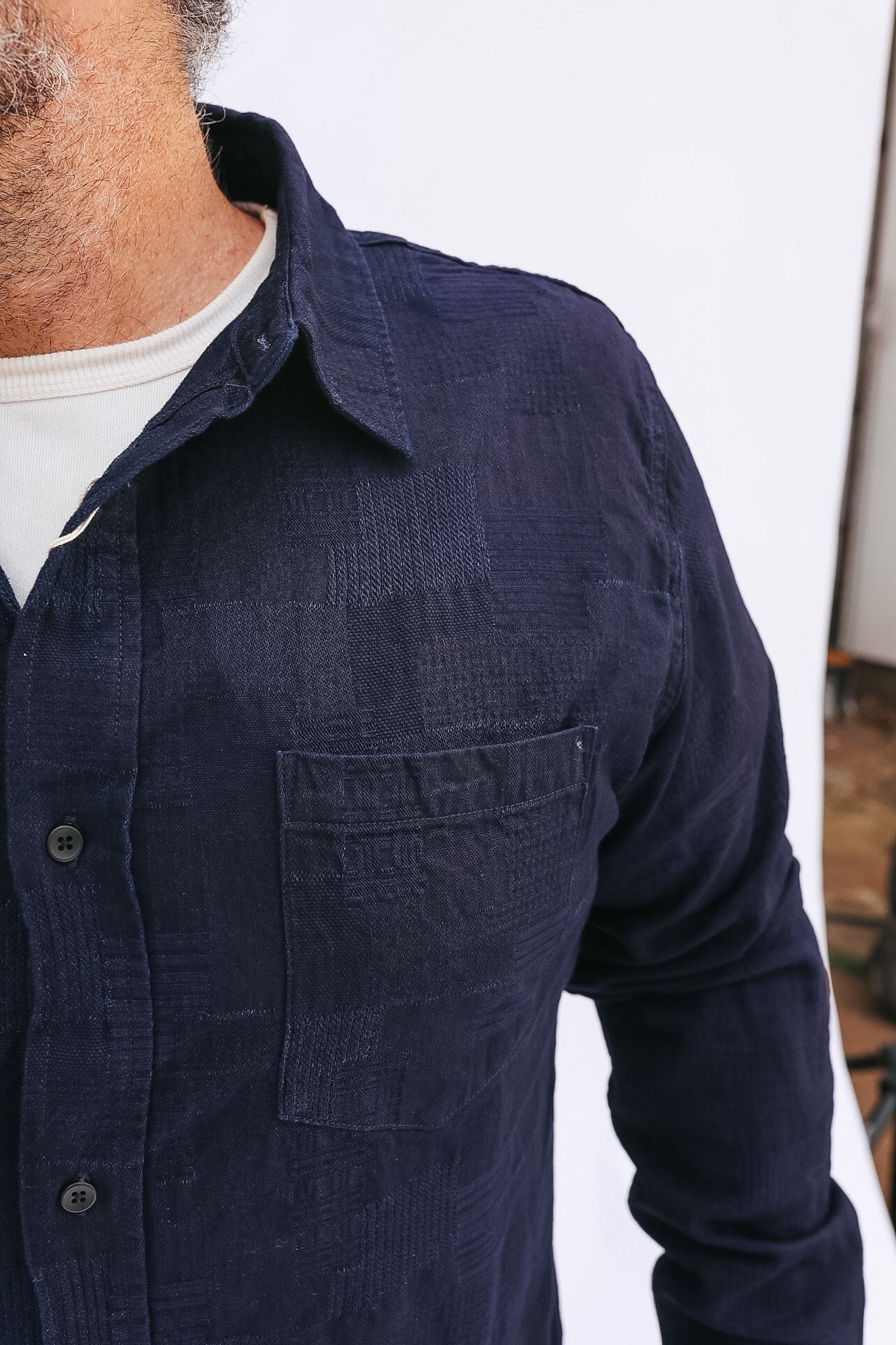 Navy blue button-up shirt worn by a person with a blurred background