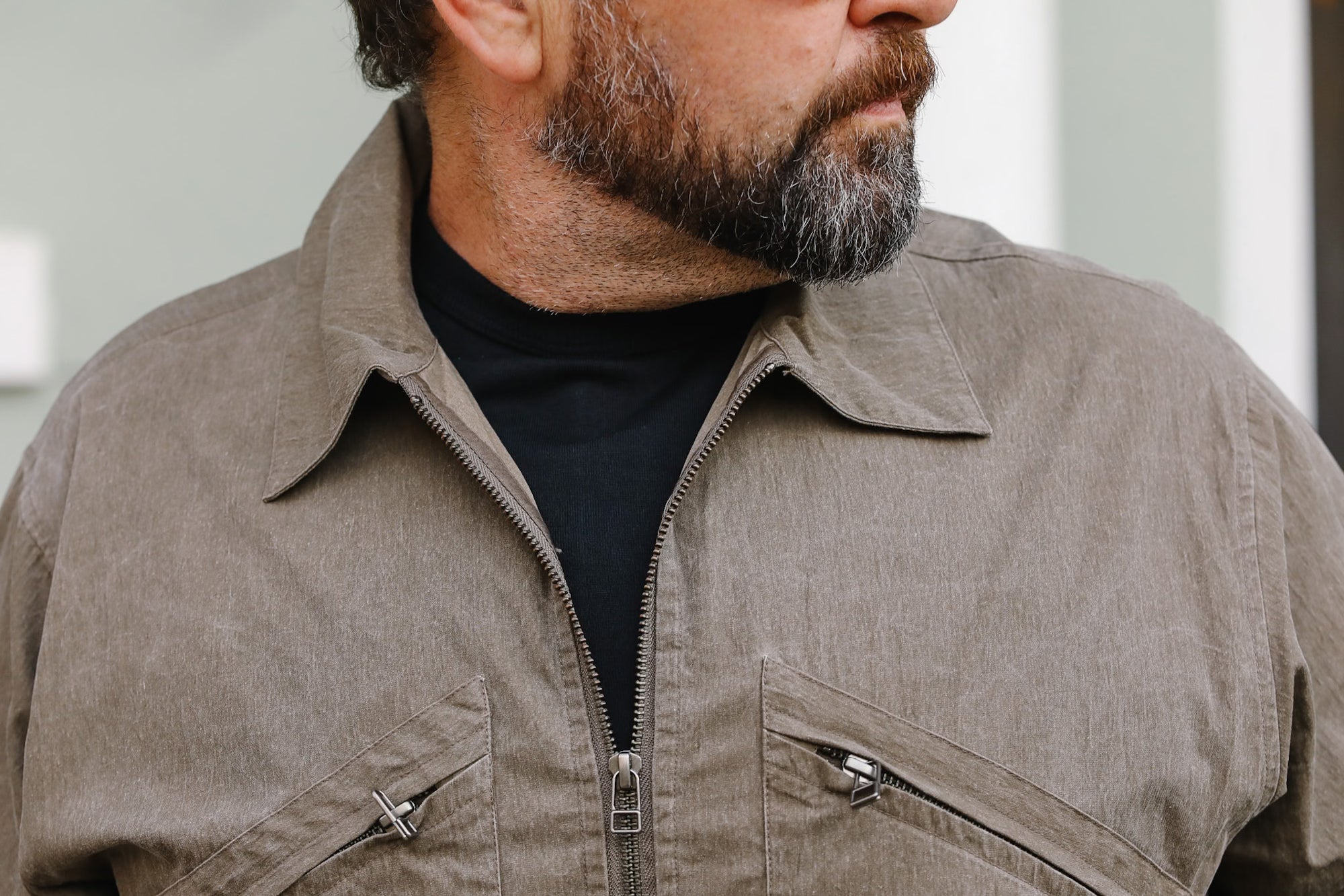 Man wearing a brown jacket with a blurred background