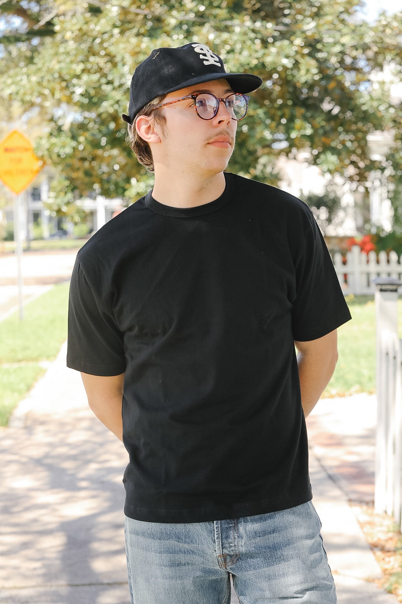 Person wearing a black t-shirt and cap outdoors