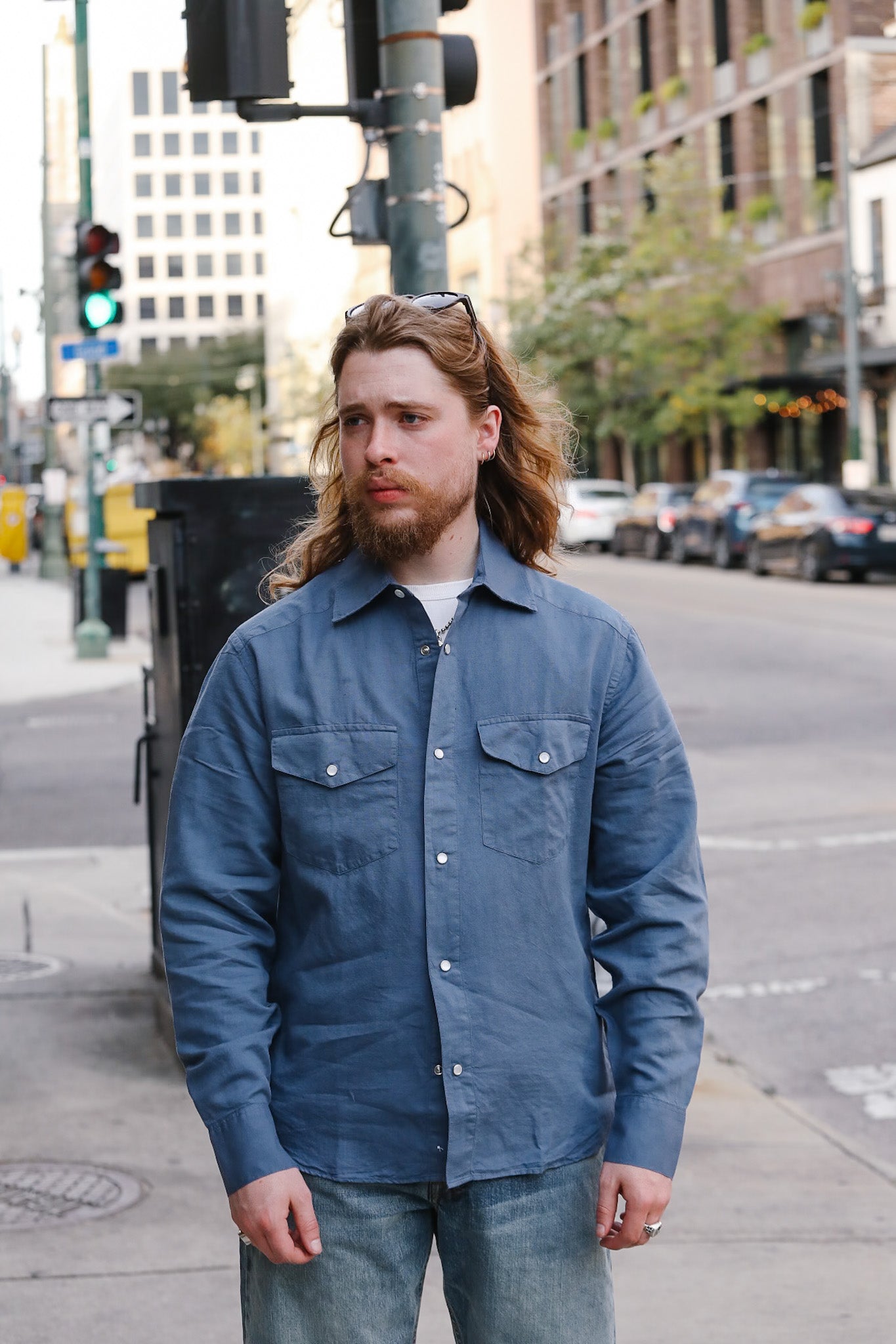 Man wearing a blue jacket standing on a city street