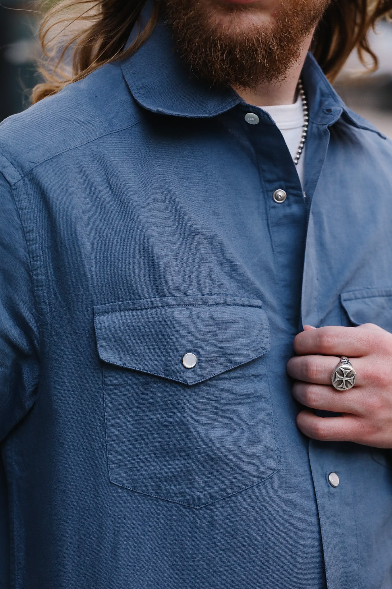 Person wearing a blue shirt with a close-up of the chest area.