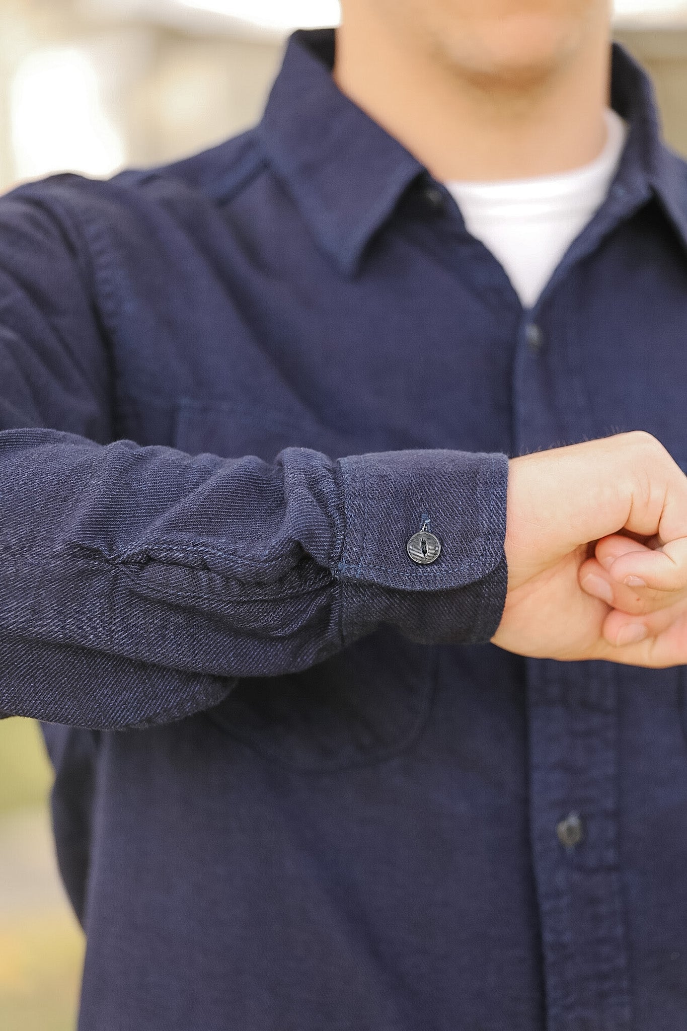 man wearing dark blue shirt on sidewalk