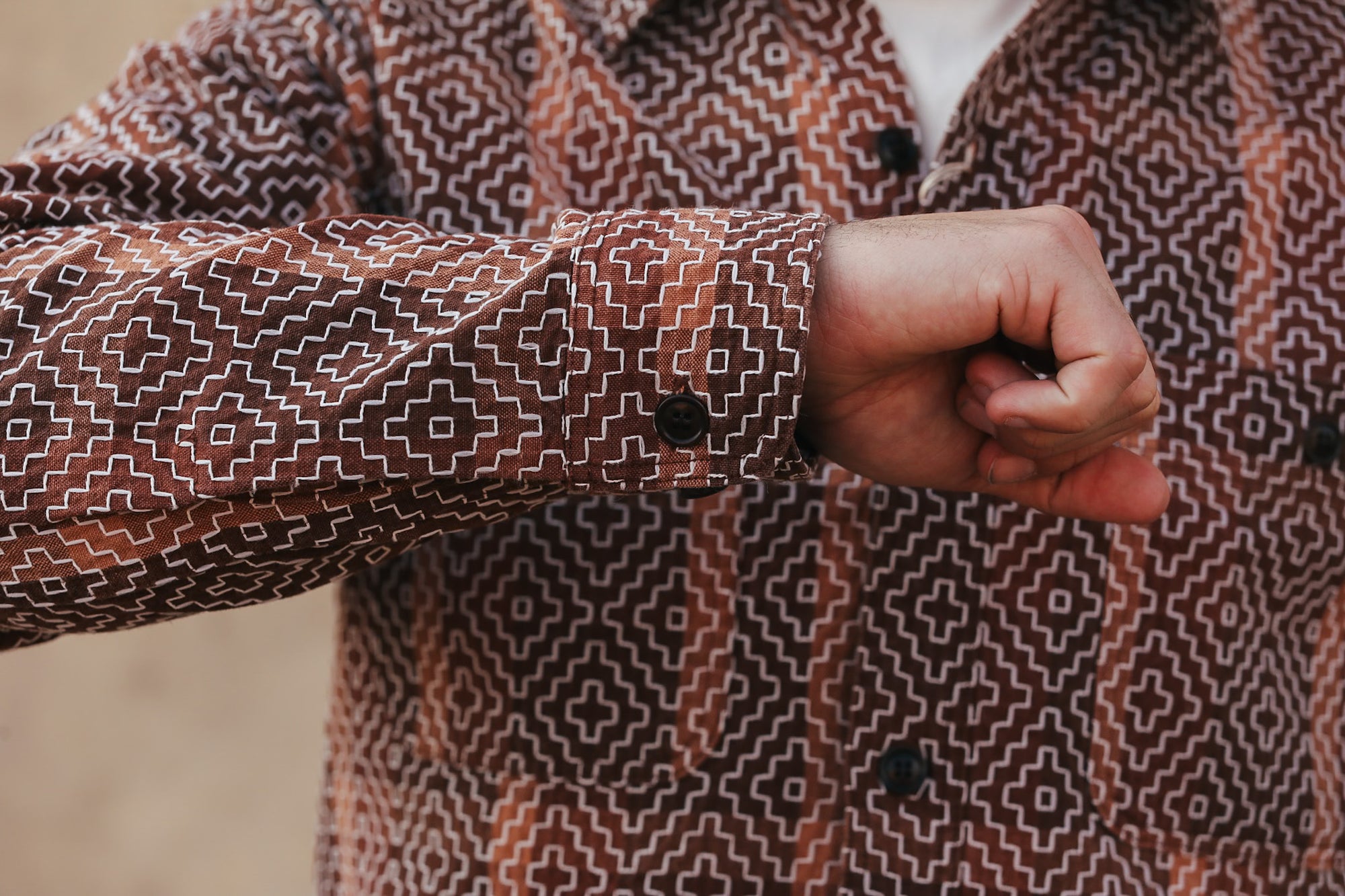 Person wearing a patterned coat with a blurred background