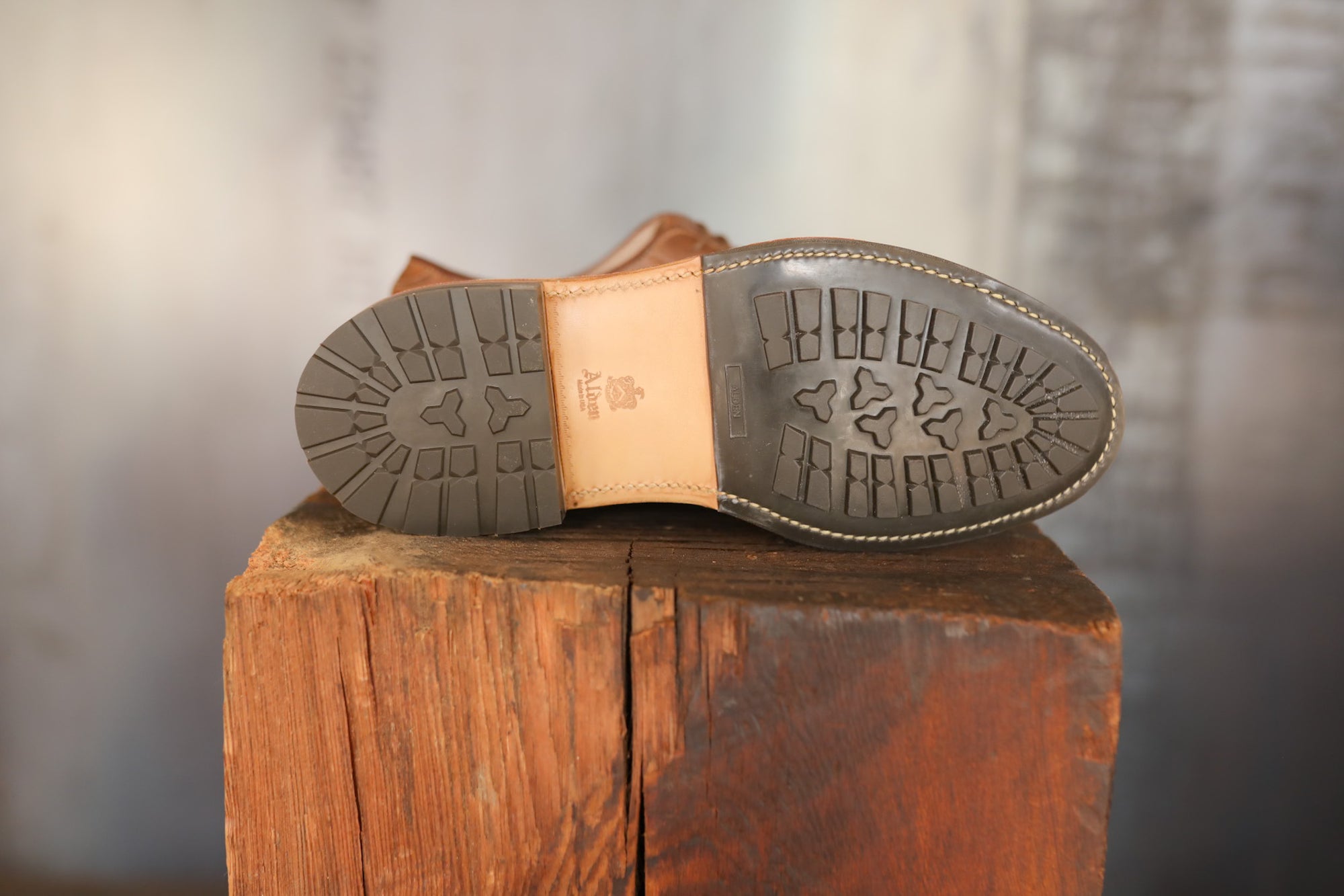 Close-up of a brown leather shoe sole on a wooden block with a blurred background