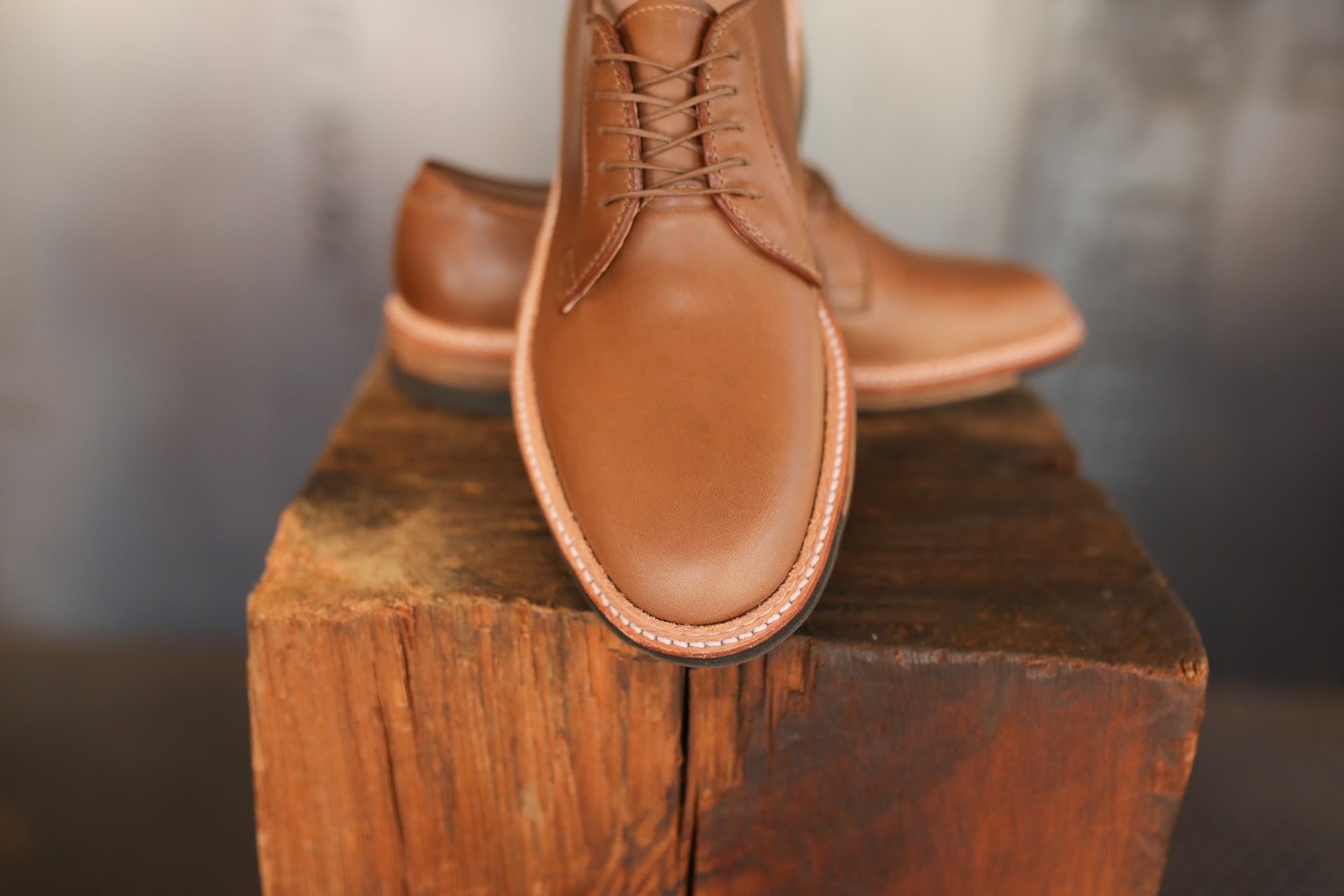 Brown leather shoes on a wooden block with a blurred background