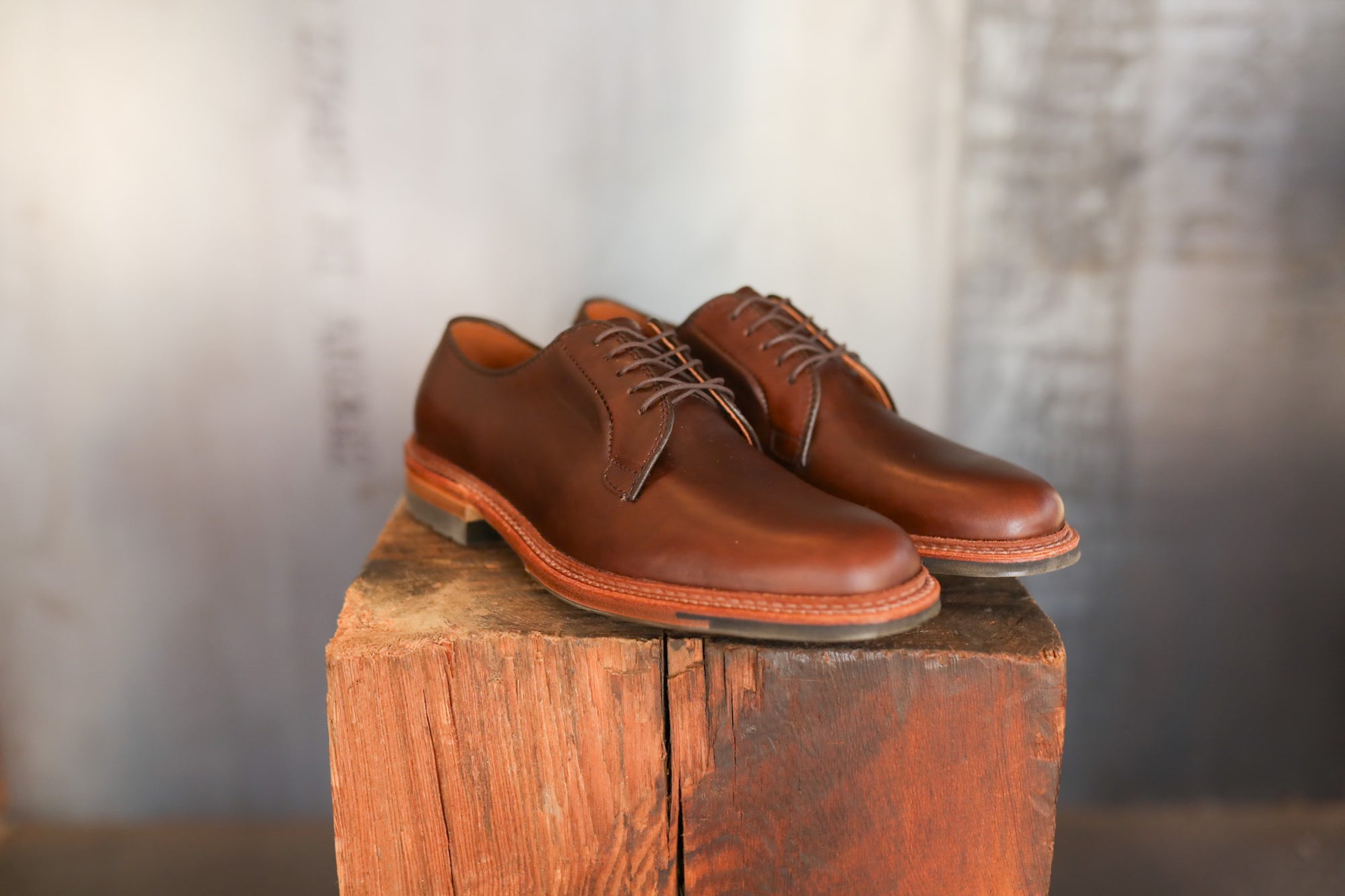 Pair of brown leather shoes on a wooden block with a blurred background