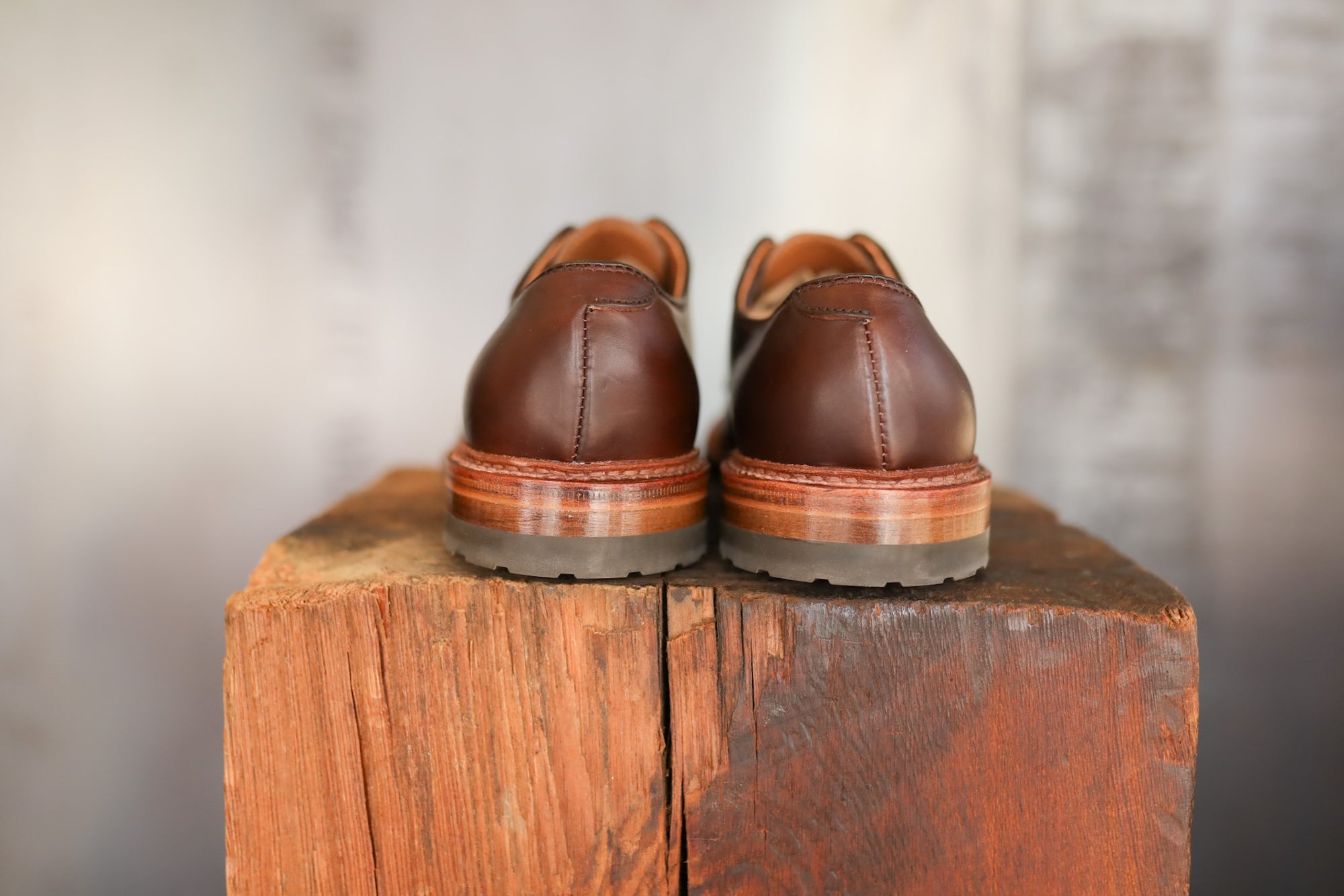 Pair of brown leather shoes on a wooden block with a blurred background