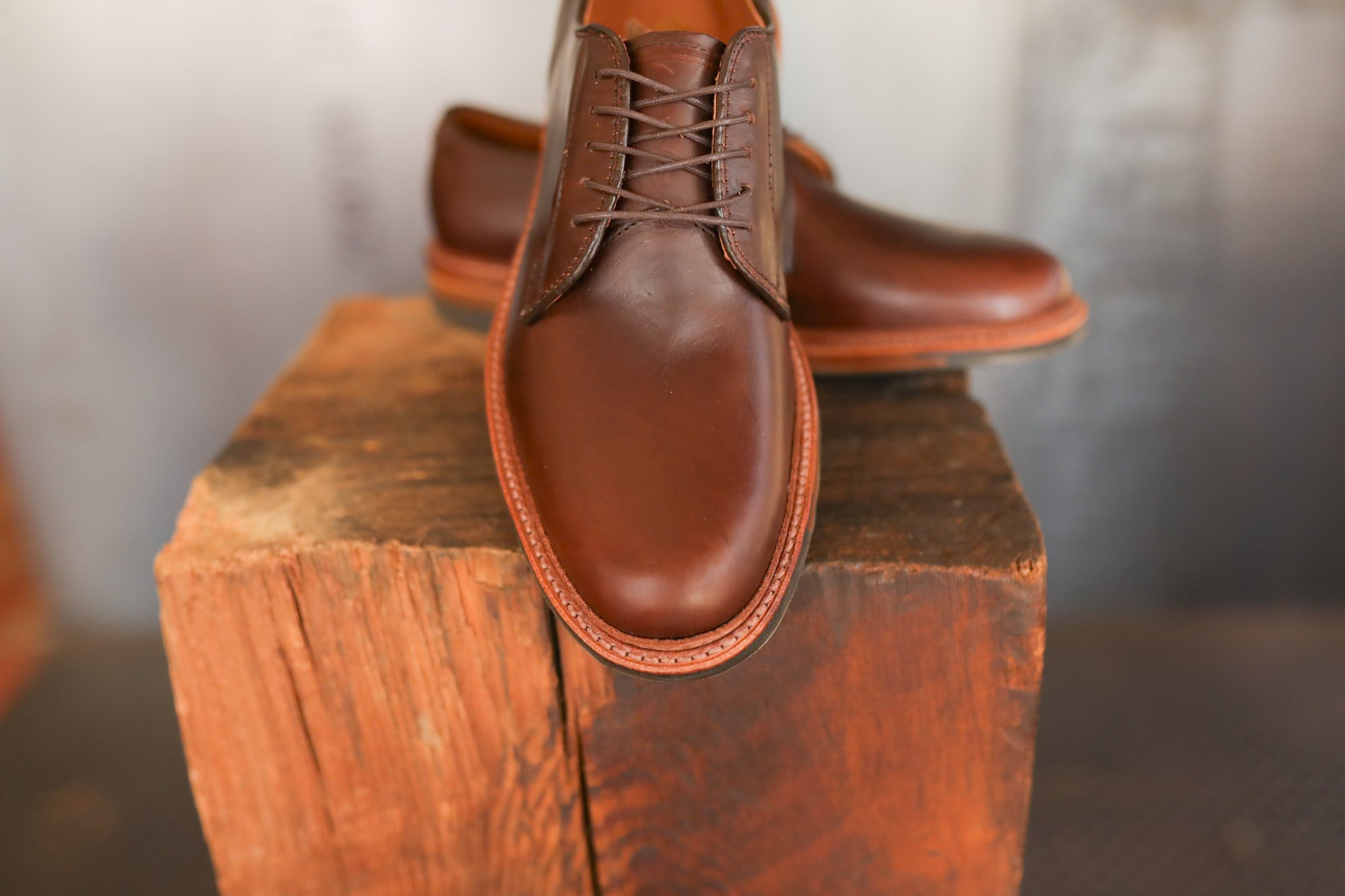Brown leather shoes on a wooden block with a blurred background