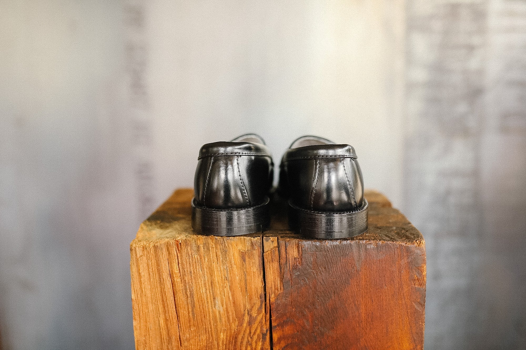 Pair of black shoes on a wooden block with a blurred background