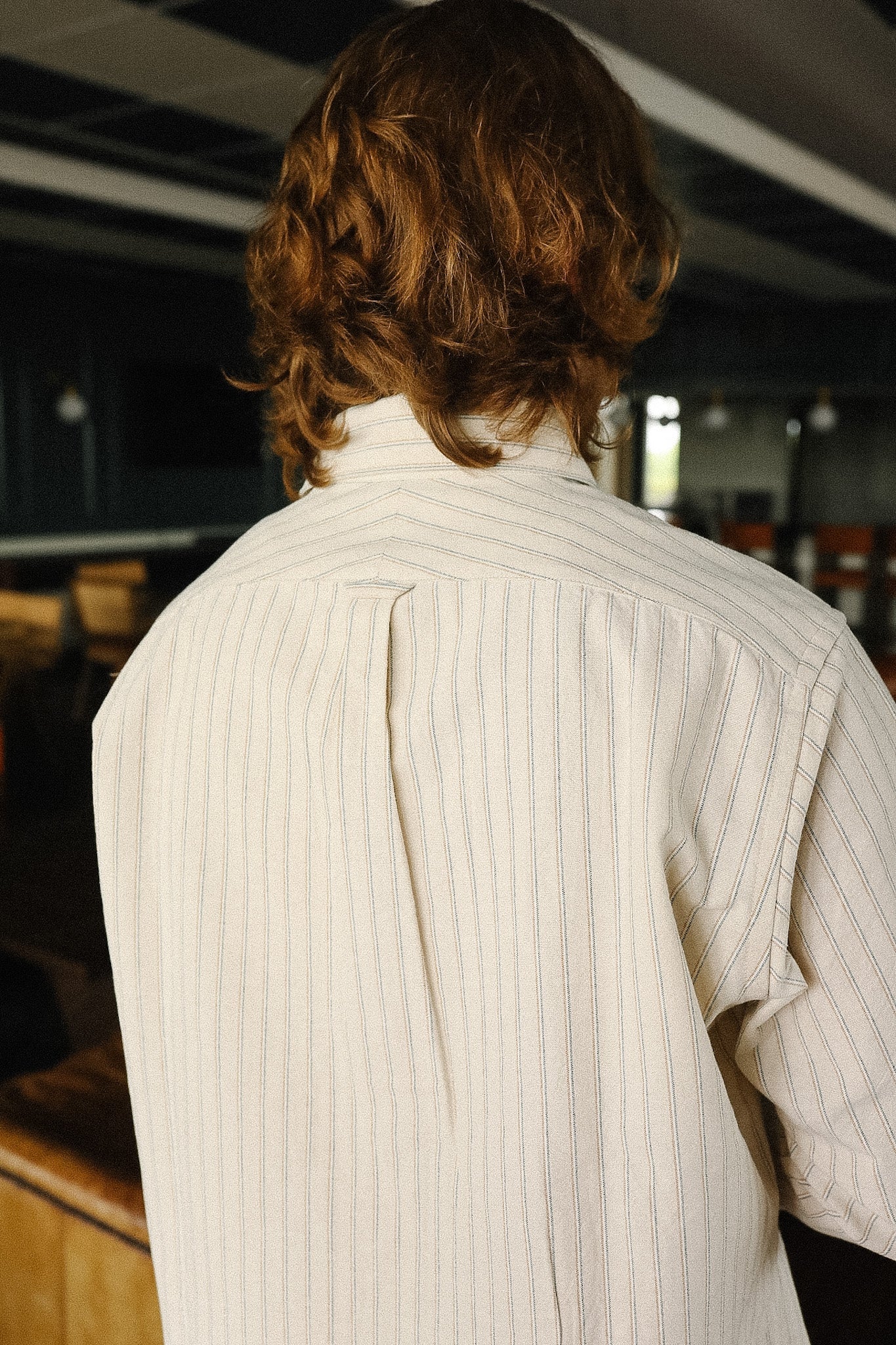Person wearing a white shirt with a blurred indoor background