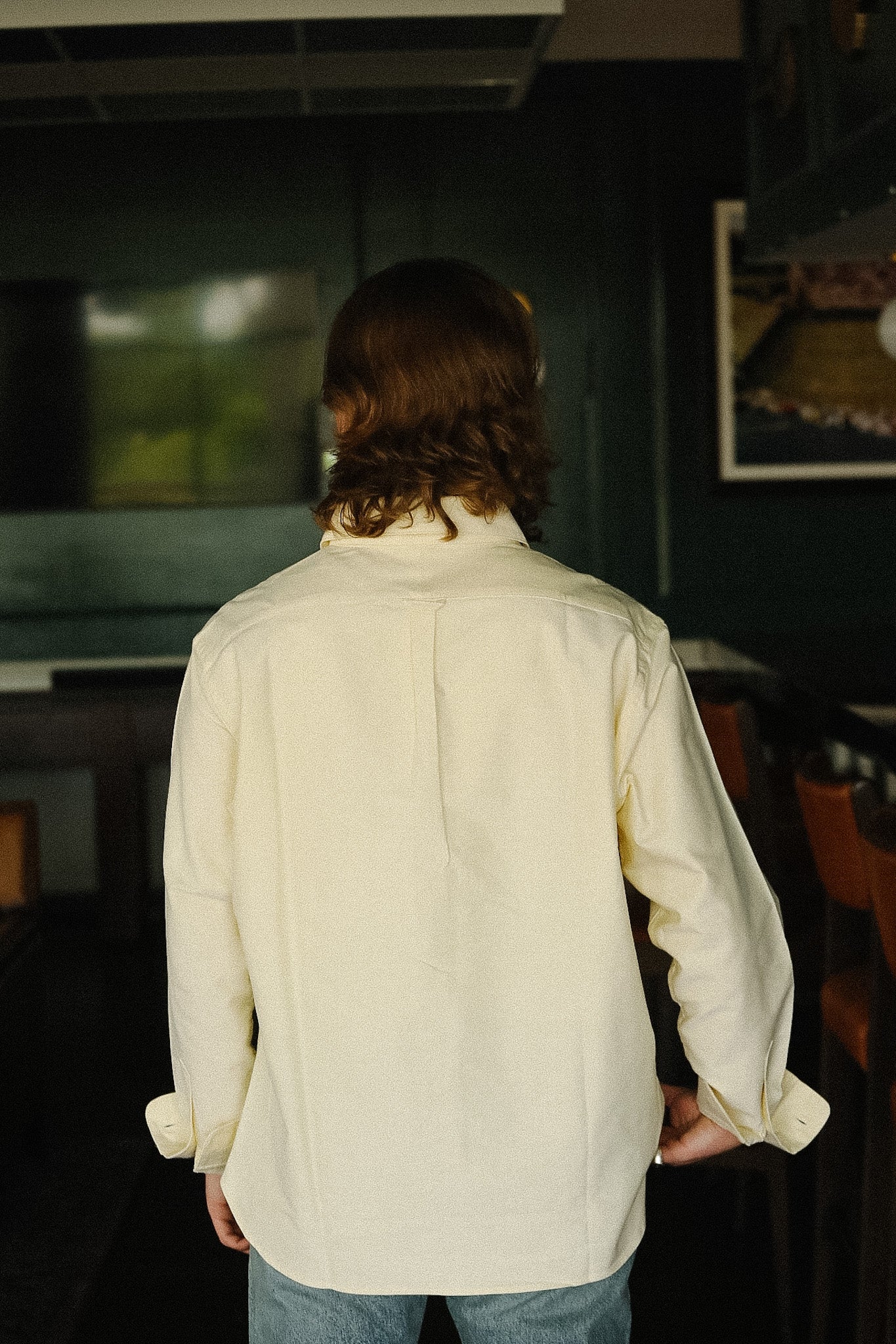 Person wearing a cream-colored shirt in an indoor setting
