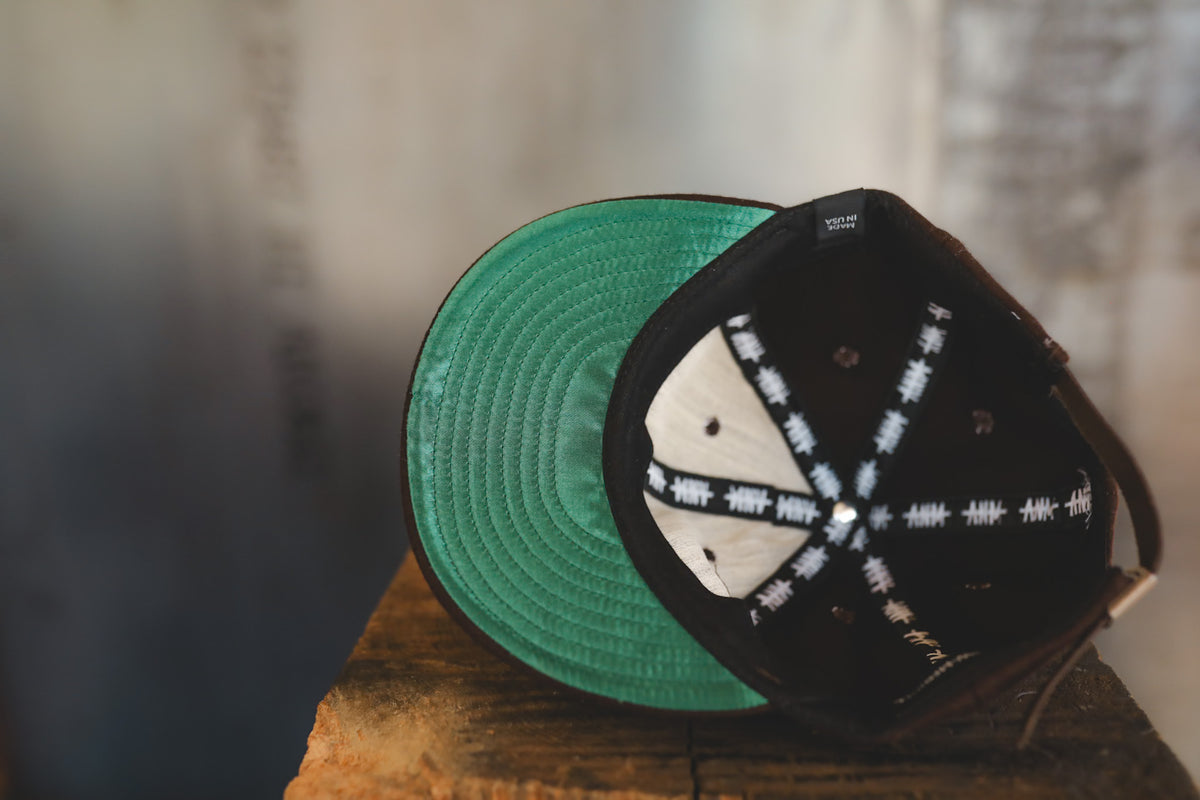 Up close of a brown baseball cap with branding 