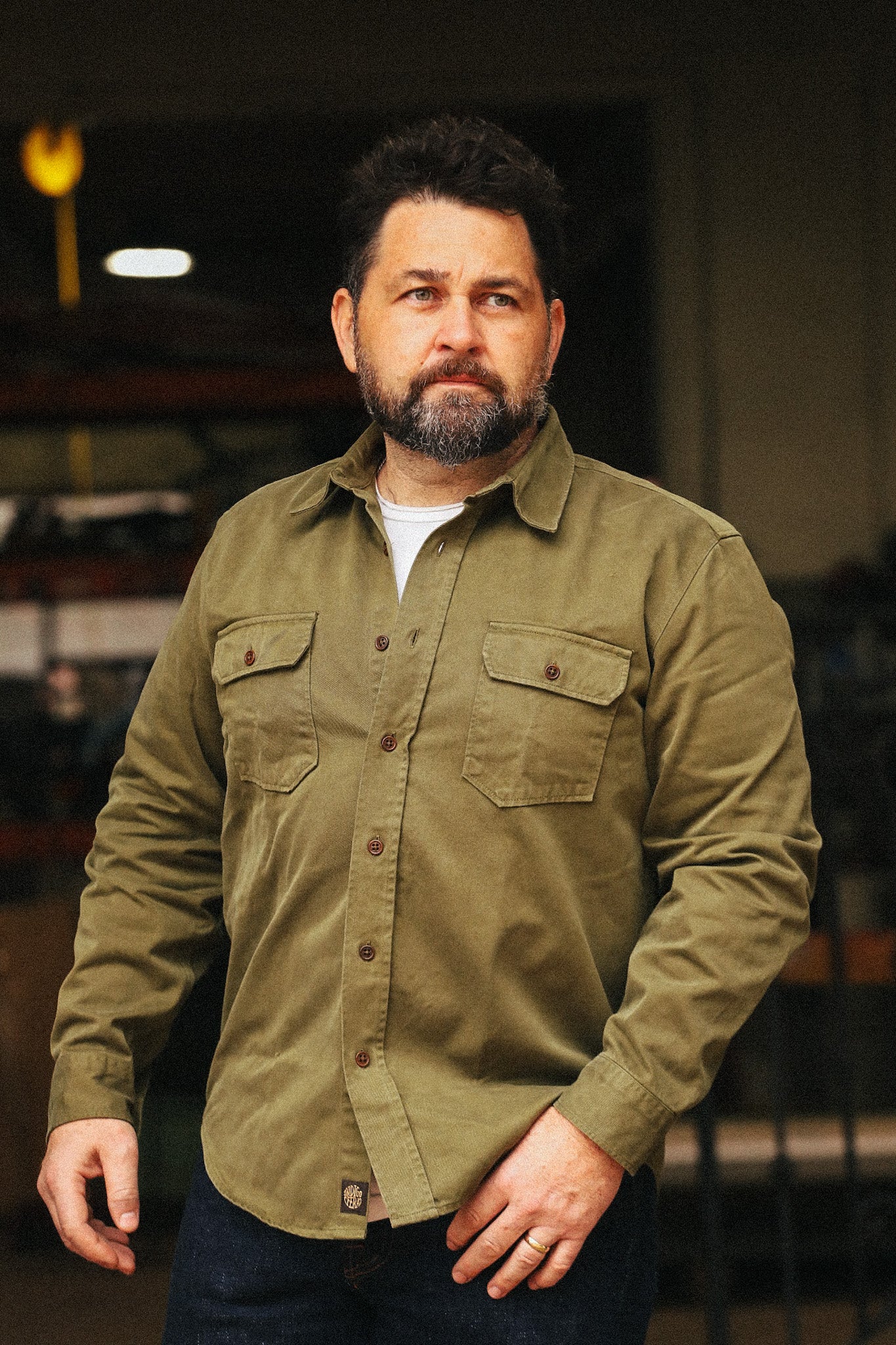 Man wearing a green jacket in an indoor setting