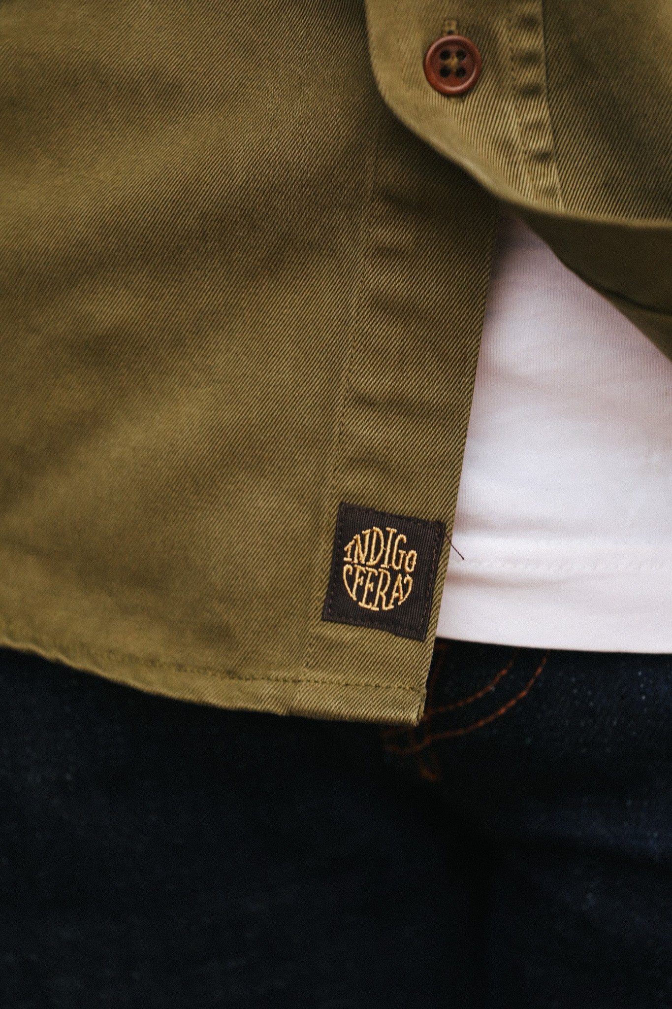 Close-up of a green jacket with a brand logo on a dark background