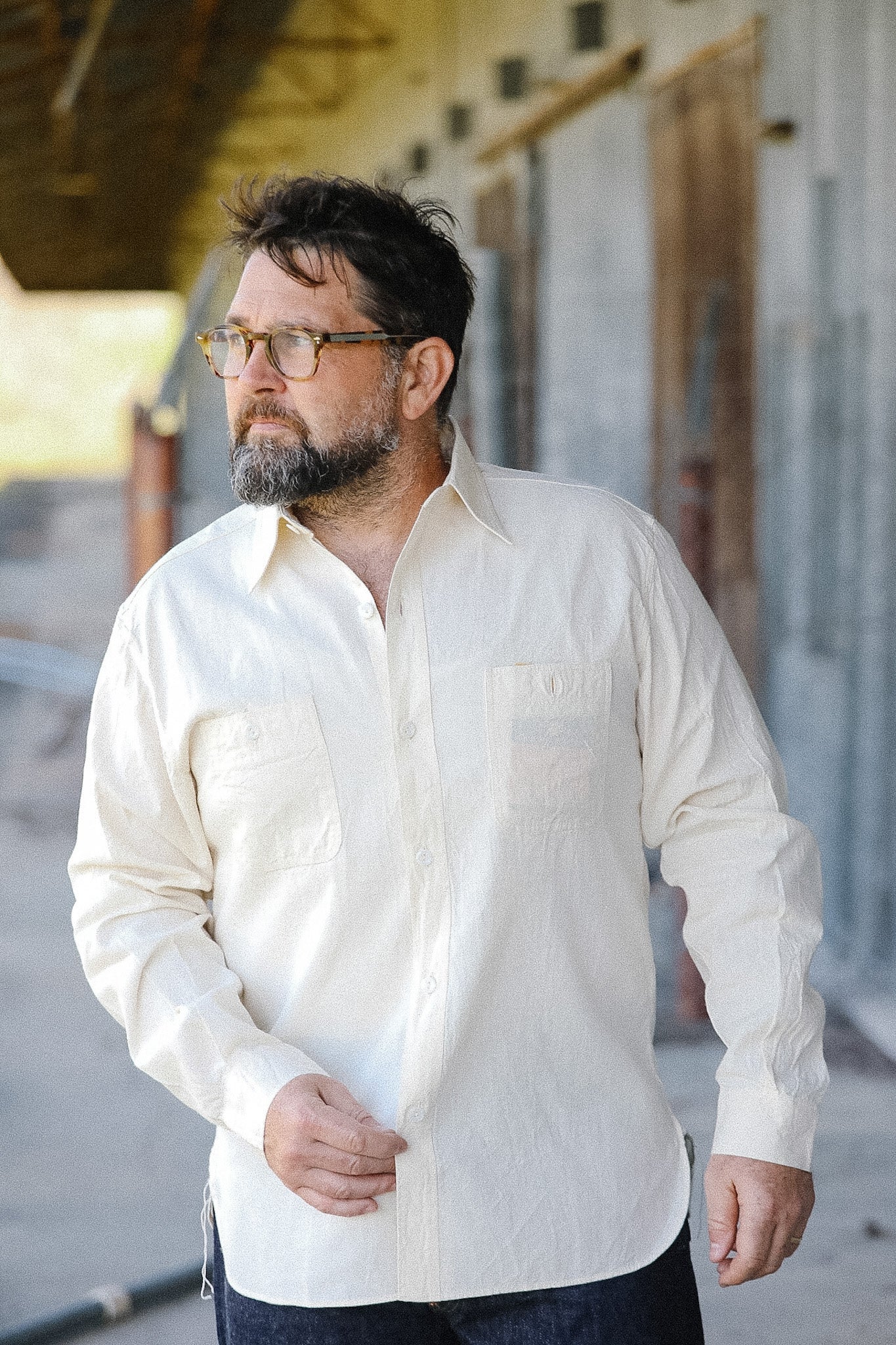 Man wearing a white shirt standing outdoors with a neutral background