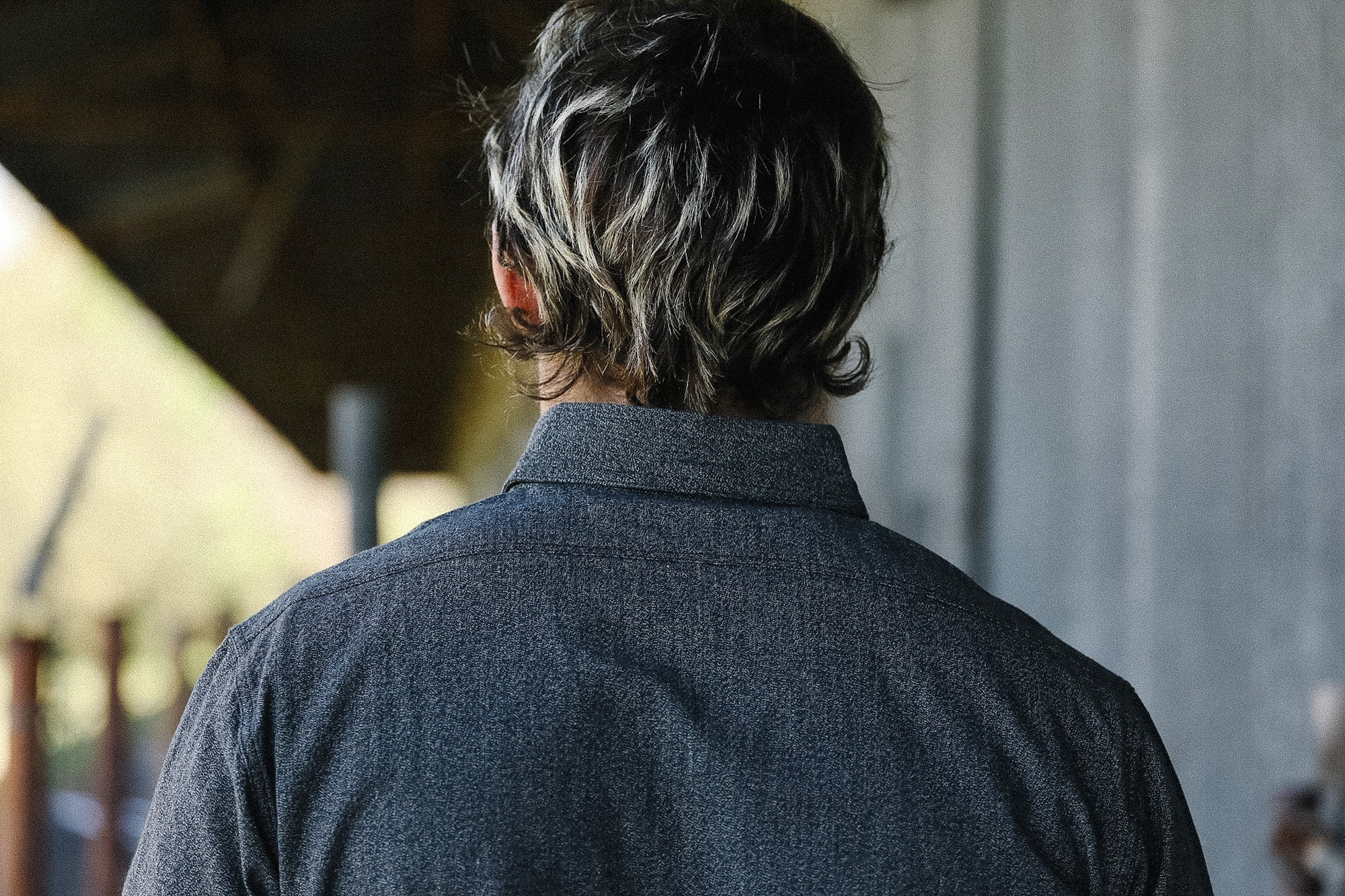 Person wearing a dark shirt with a blurred background