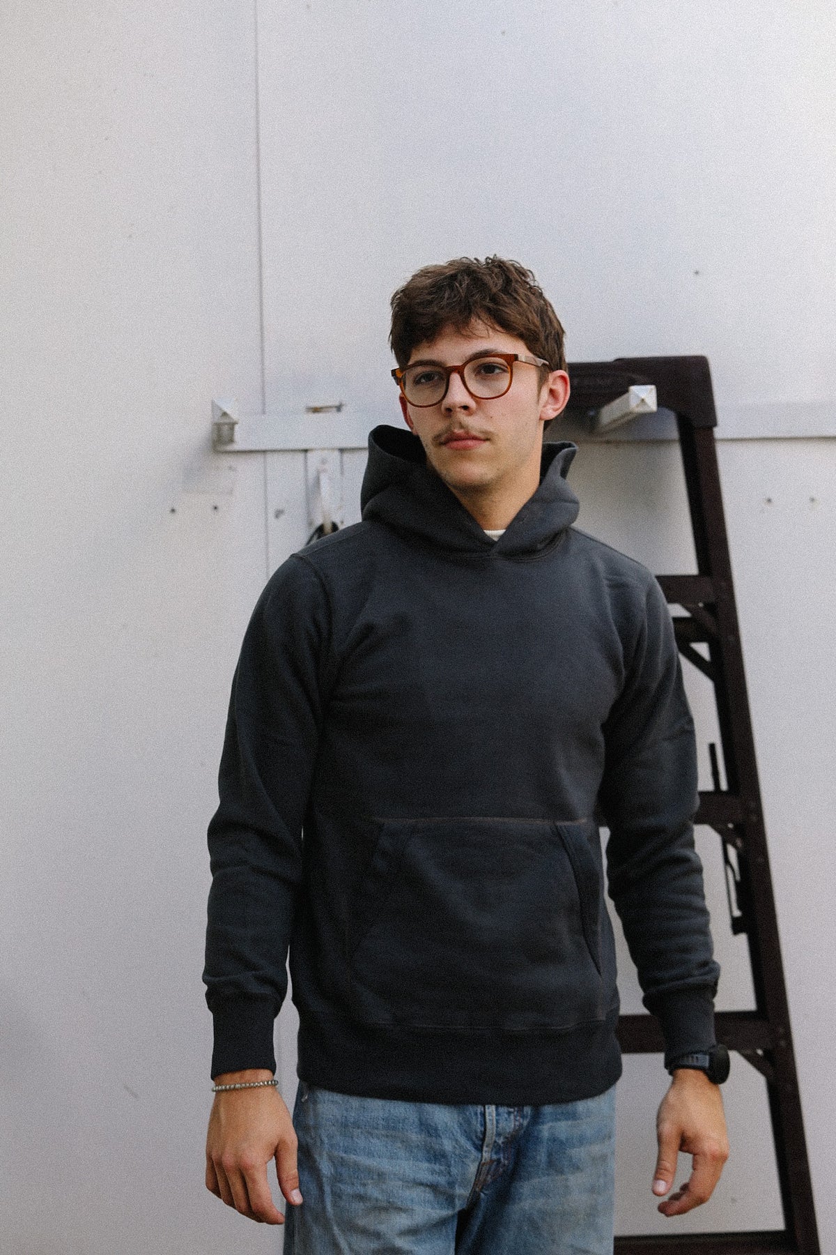 man wearing a black sweater on a white backdrop