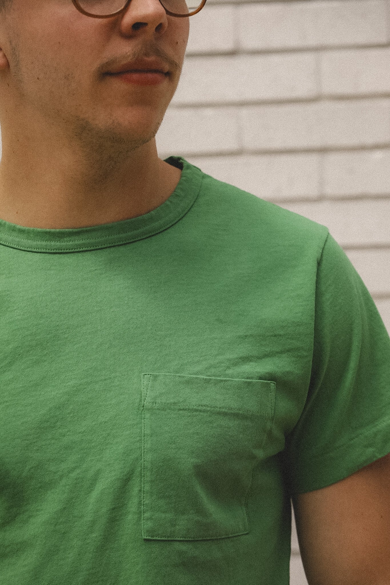Man wearing a green t-shirt against a neutral background