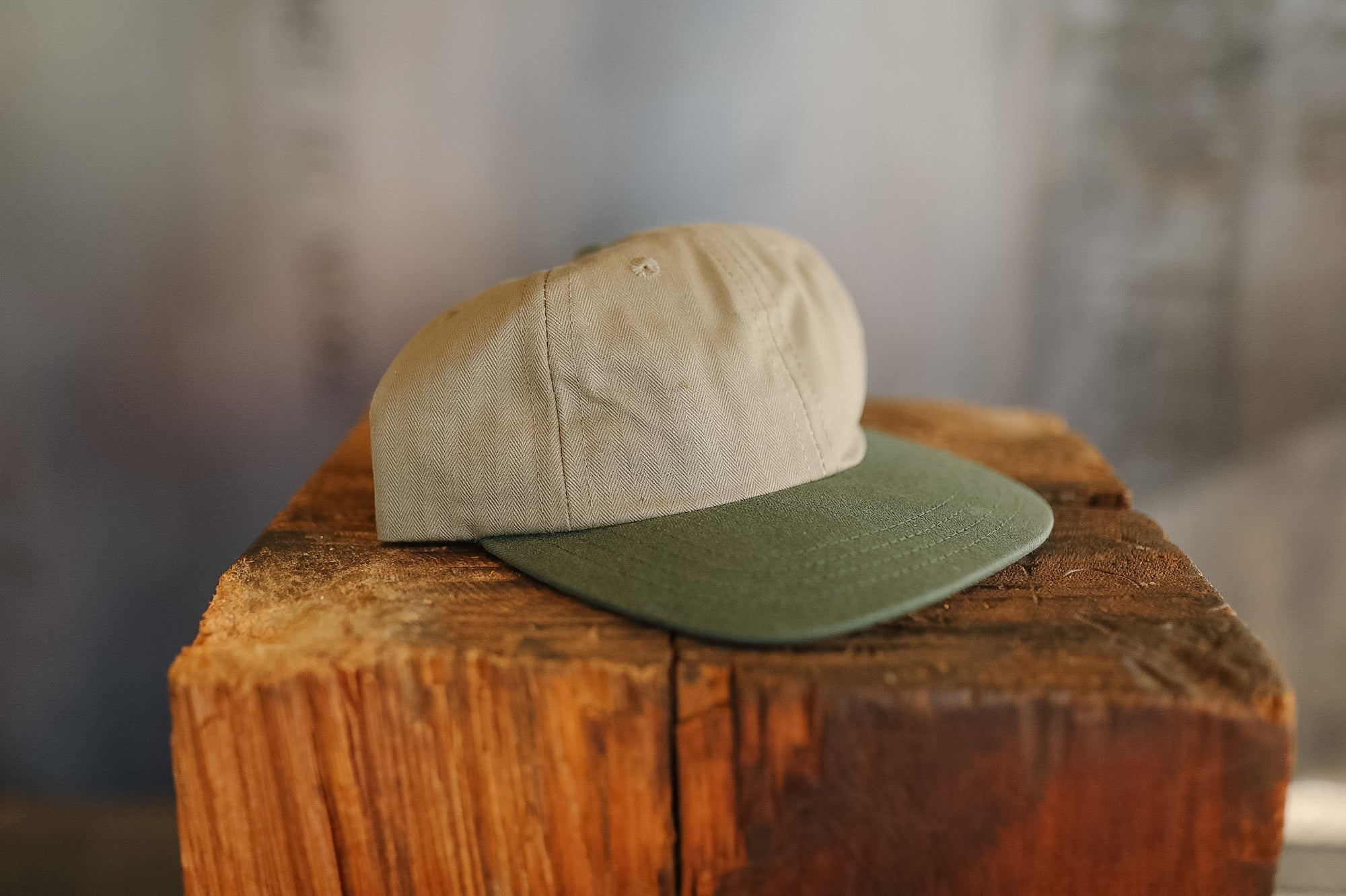 Two caps stacked on a wooden block with a blurred background