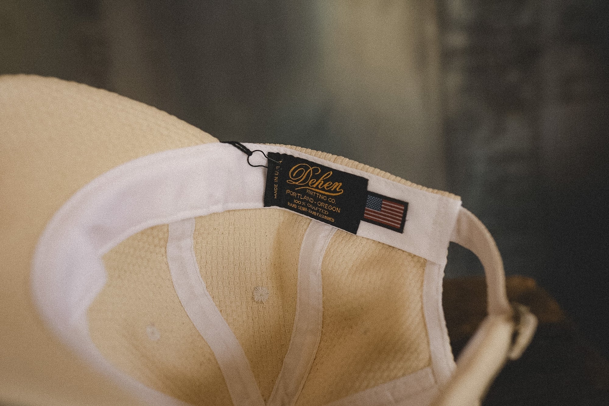 Beige cap with a brand label on a blurred background