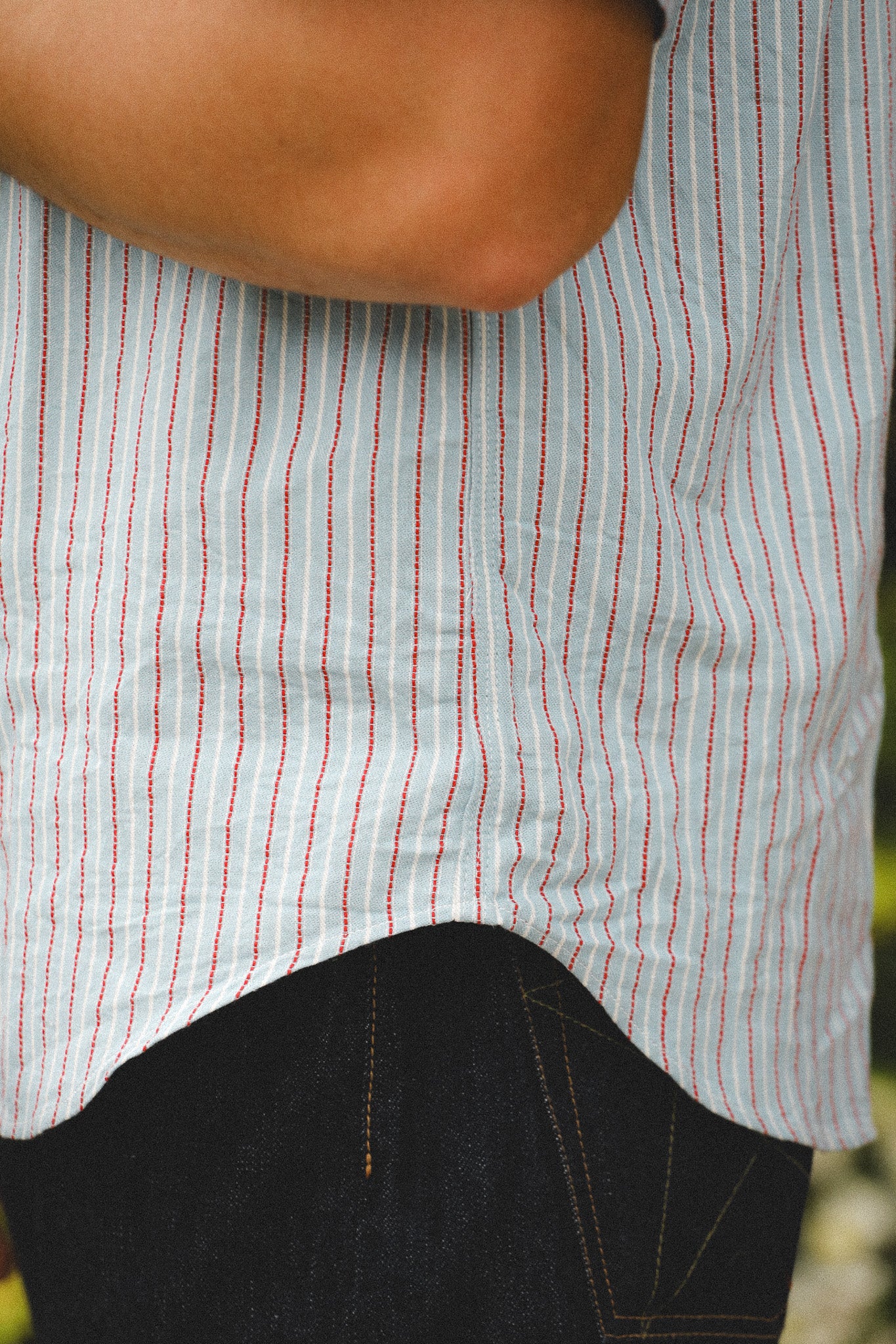 Close-up of a person wearing a striped shirt with a blurred background