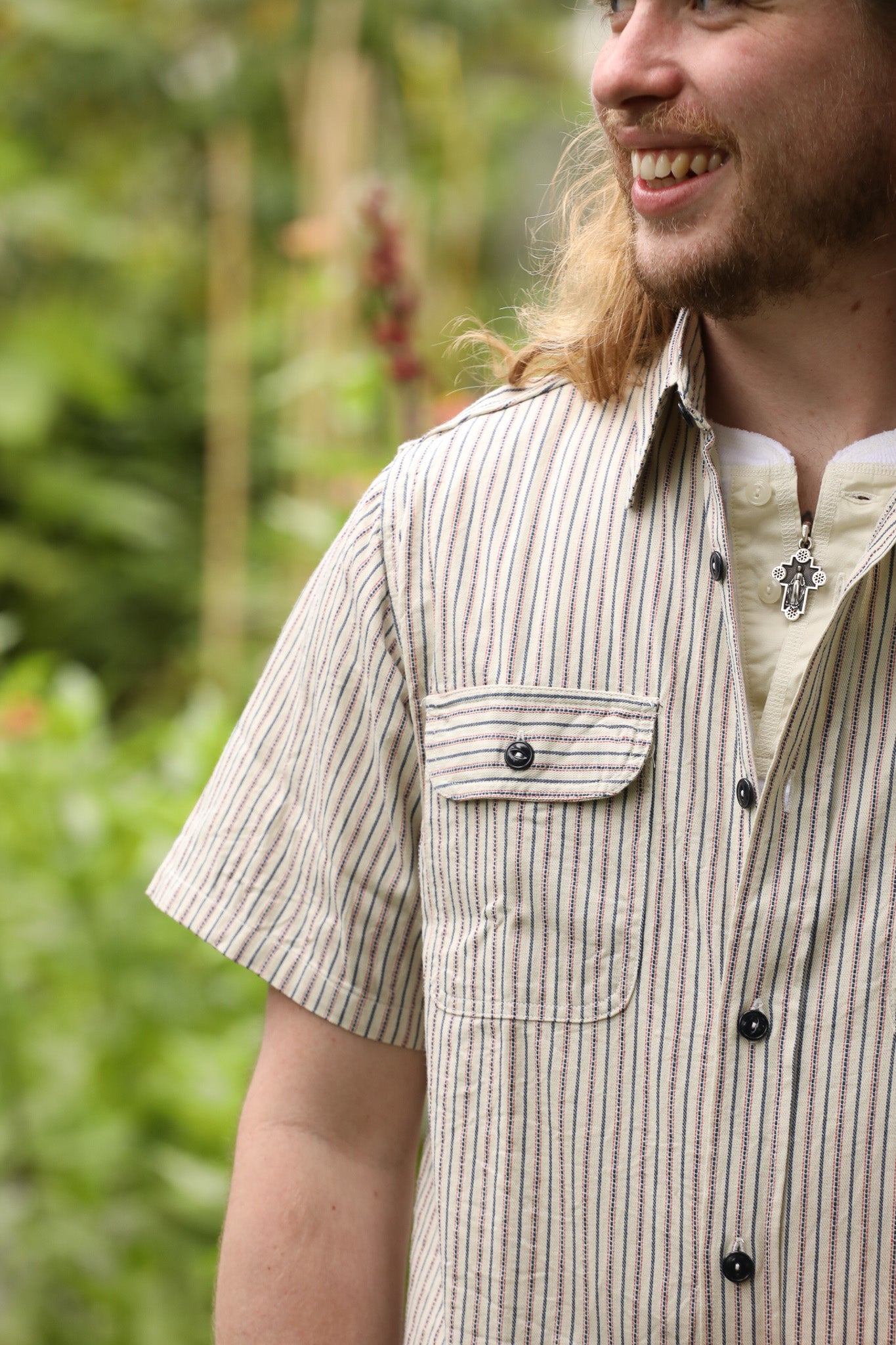 Man wearing a striped shirt with a blurred natural background