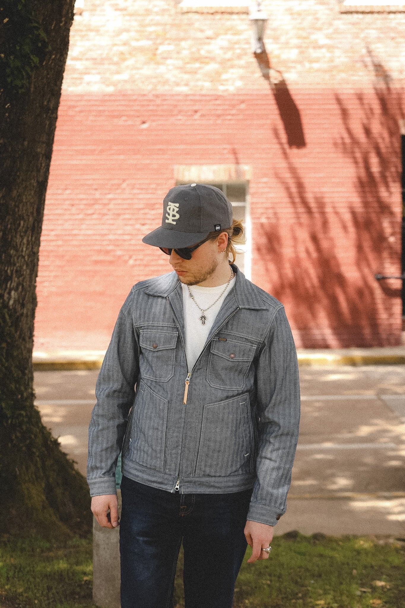 man wearing denim stripe jacket outdoors with a blurred background 
