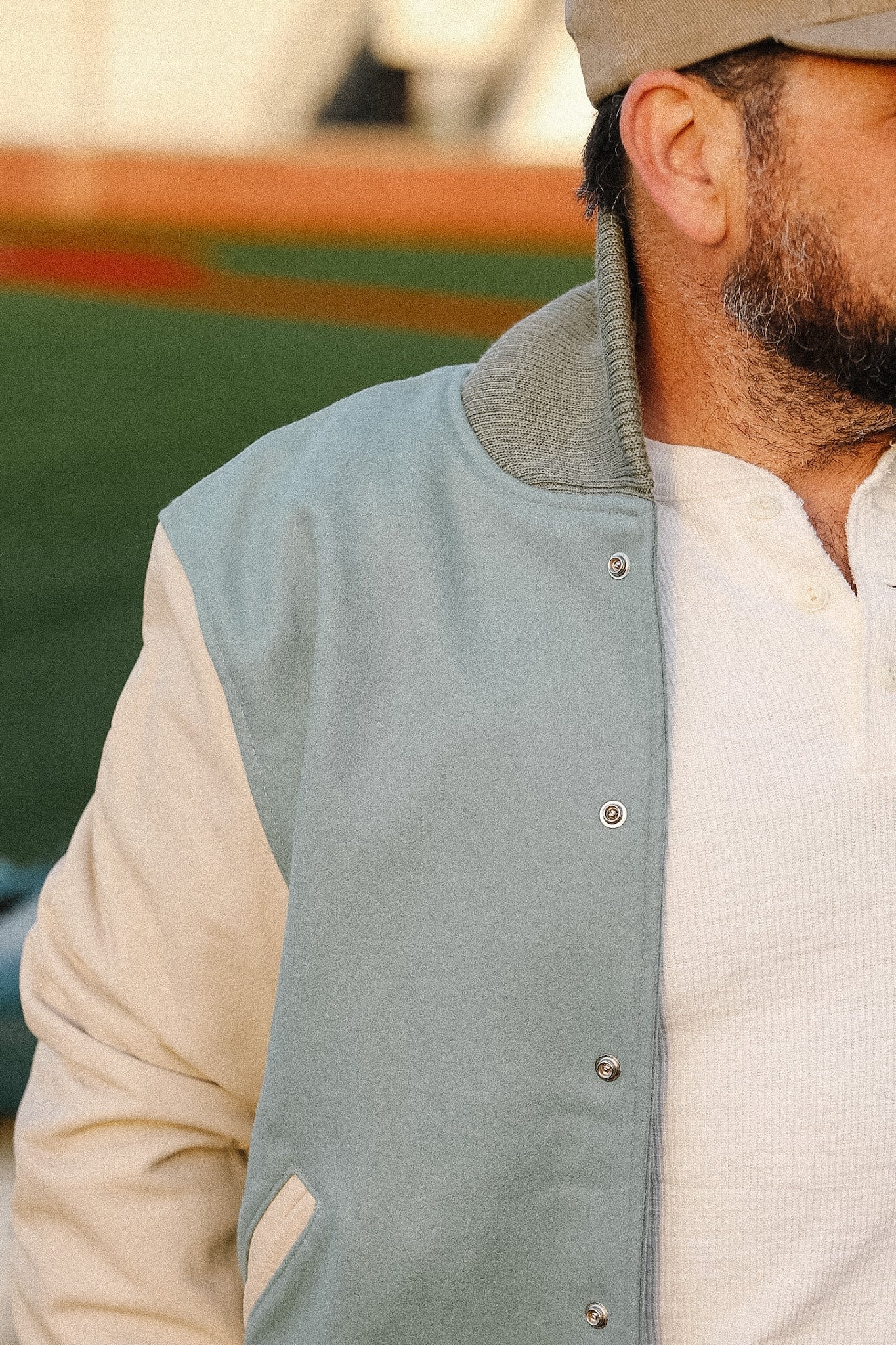 Person wearing a light blue vest over a white shirt with a blurred background