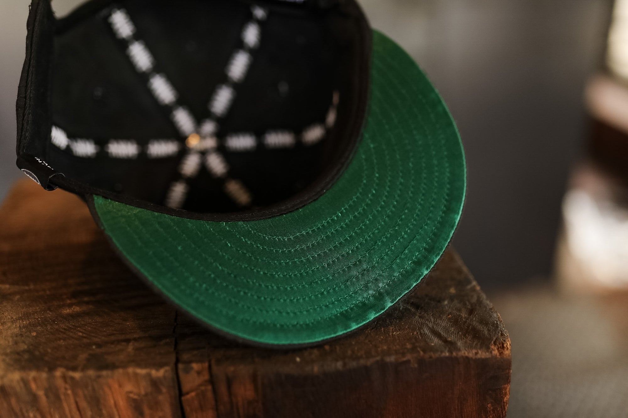 Green cap with black visor on a wooden surface
