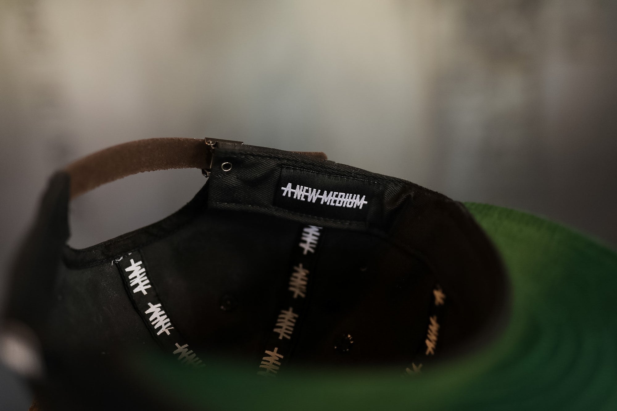 Black cap with white text on a green surface