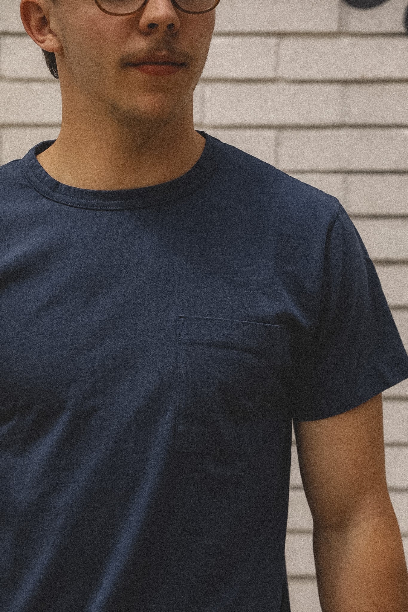 Person wearing a navy blue t-shirt against a neutral background