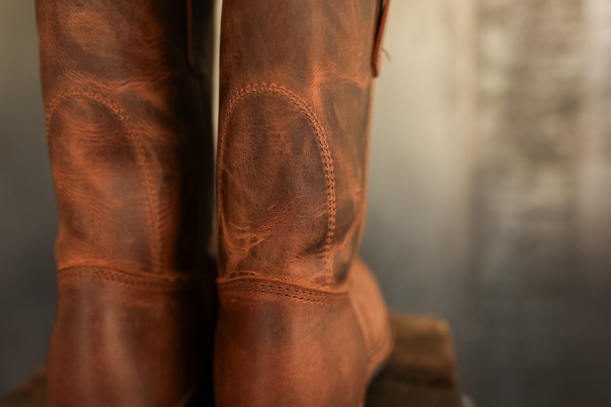 Close-up of brown leather boots with detailed stitching on a blurred background