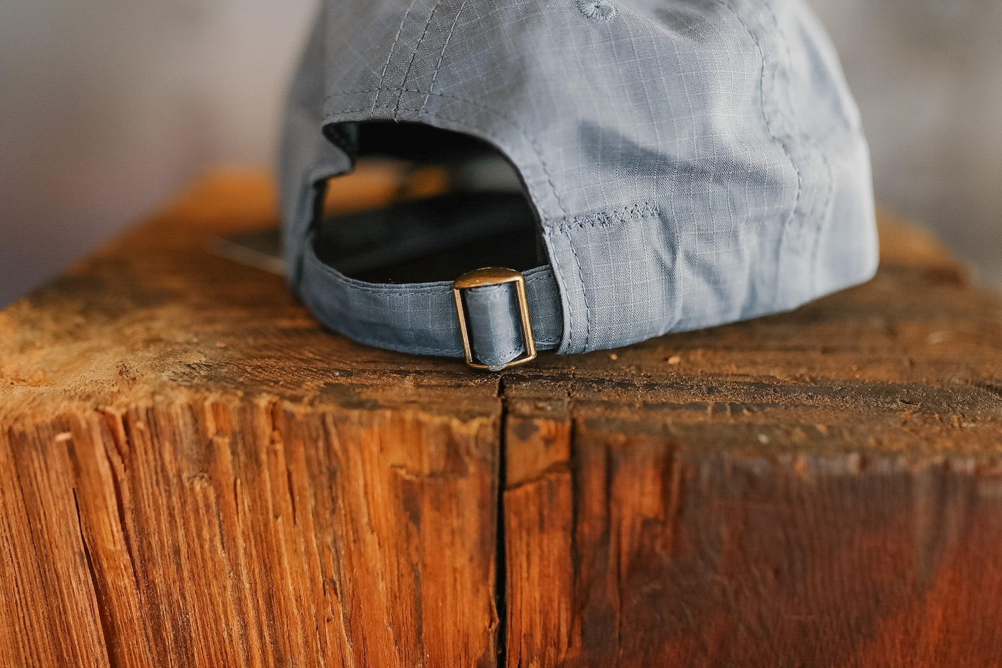 Blue cap with a gold buckle on a wooden surface
