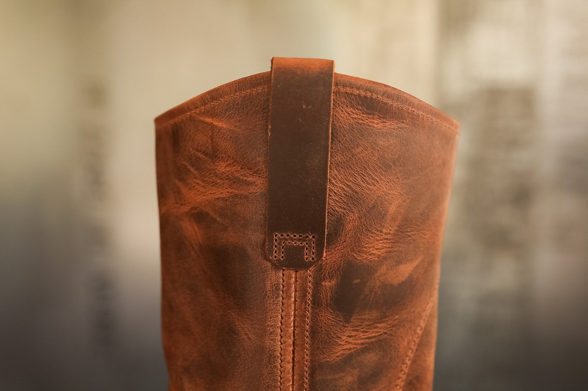 Close-up of a brown leather boot with a blurred background