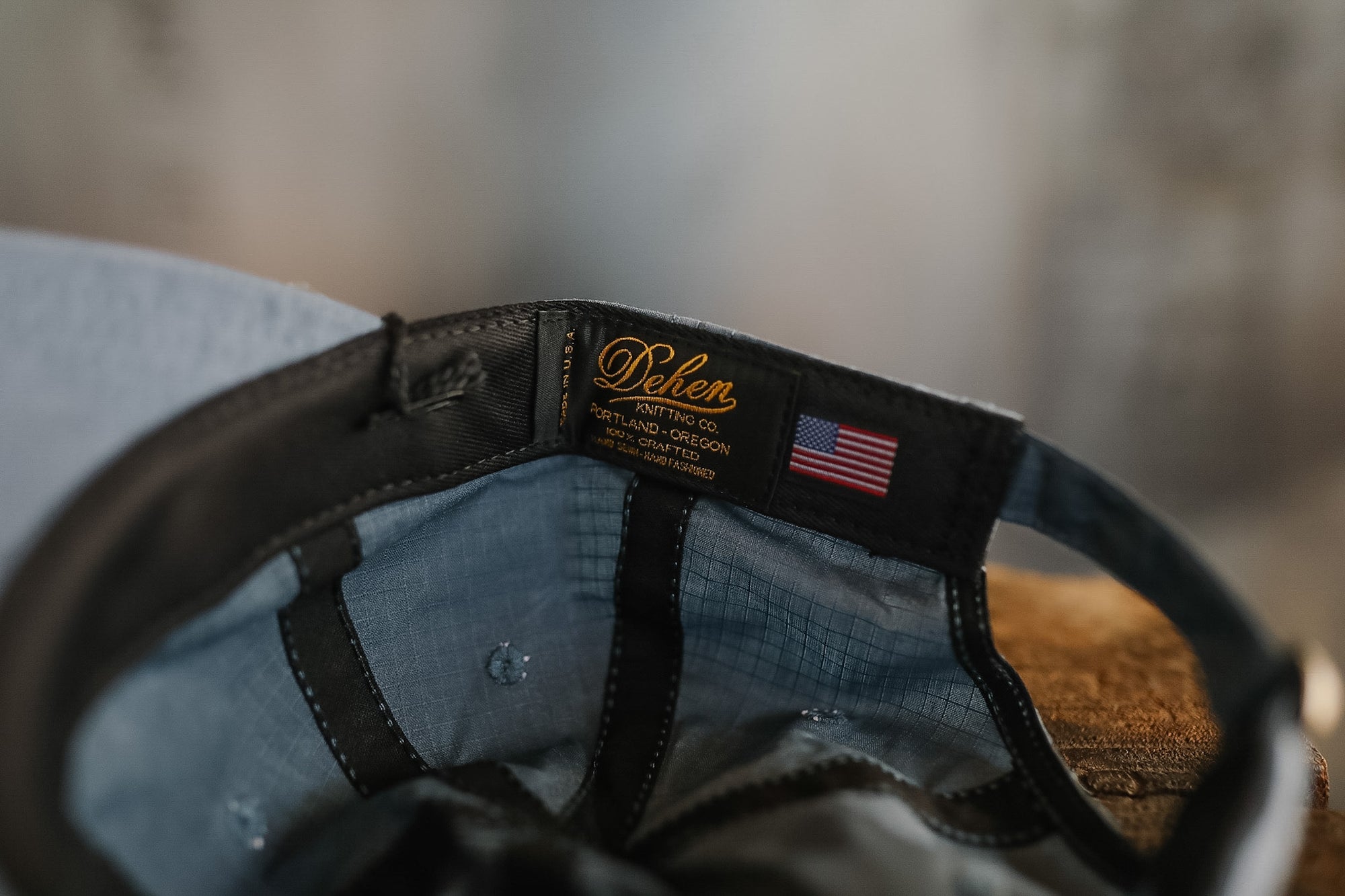 Close-up of a cap with a brand label and American flag patch on a blurred background