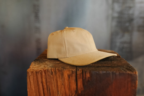 Beige cap on a wooden block with a blurred background