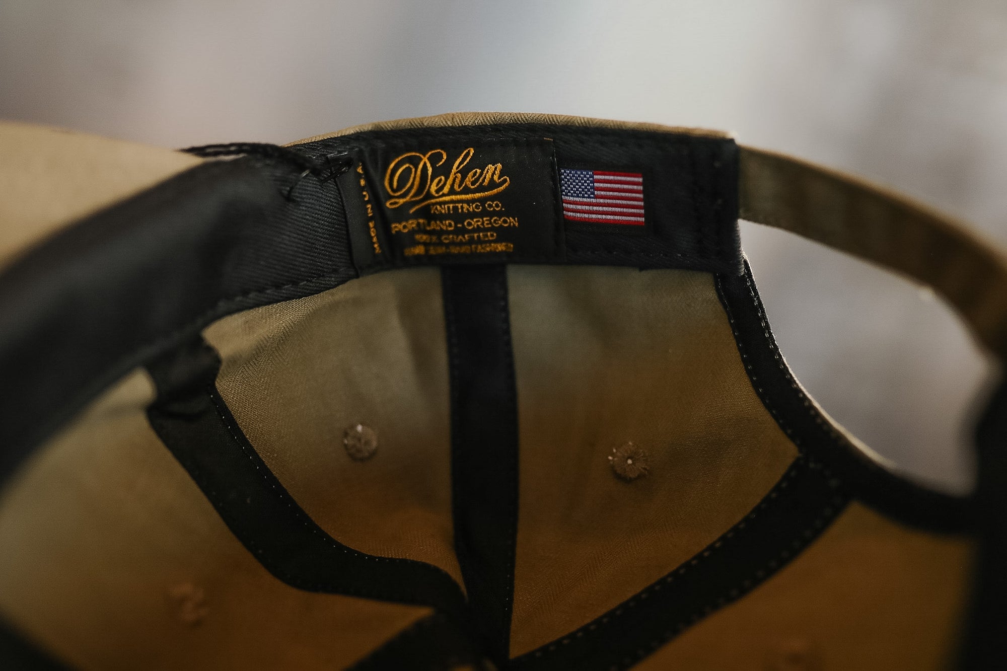 Close-up of a cap with a brand label and American flag patch on a blurred background