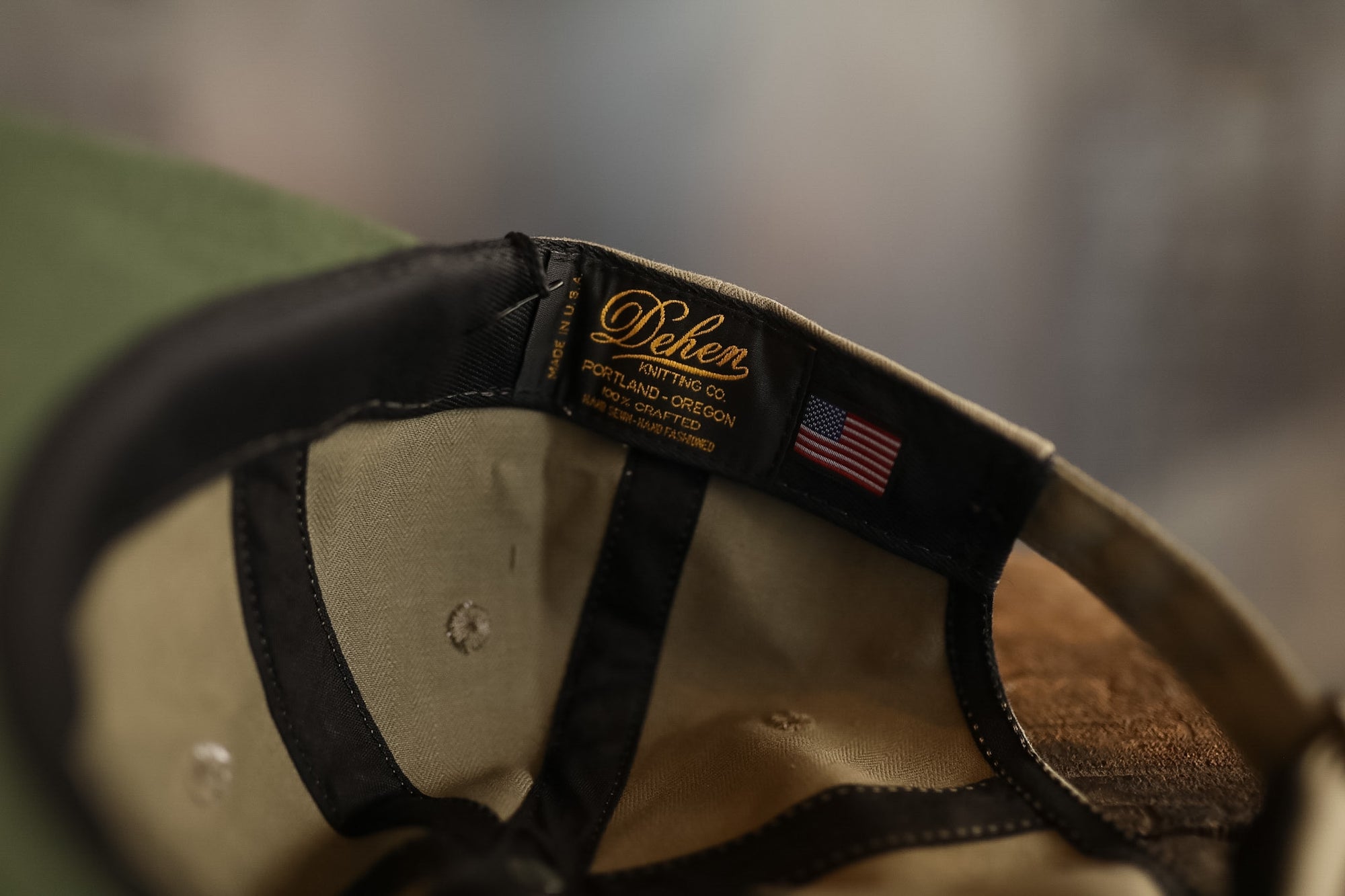 Close-up of a cap with a brand label and American flag patch on a blurred background