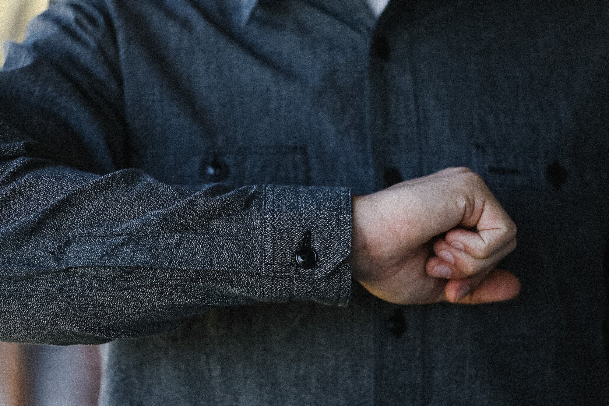 Person wearing a dark gray coat with a blurred background