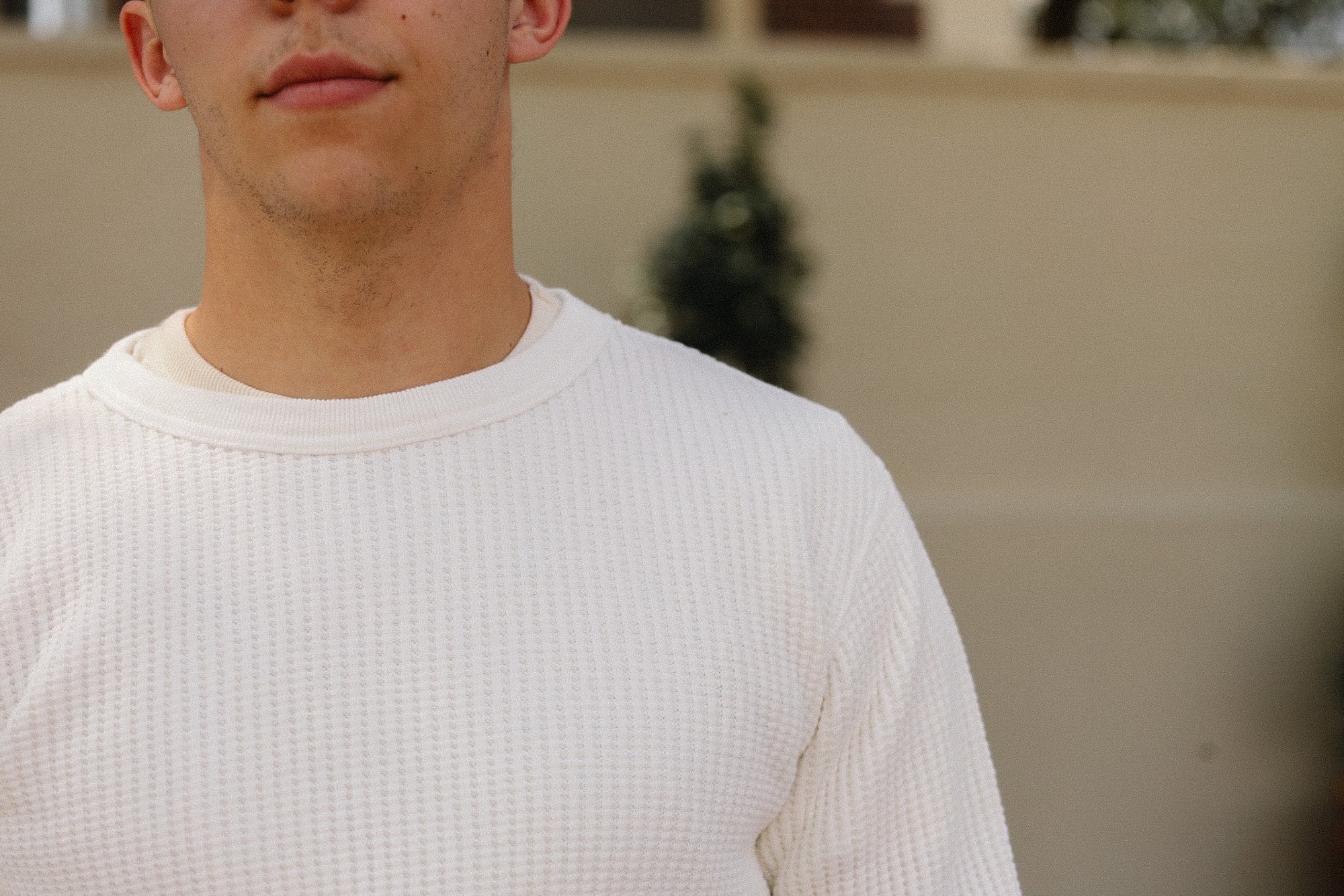 Person wearing a white thermal shirt with a blurred background