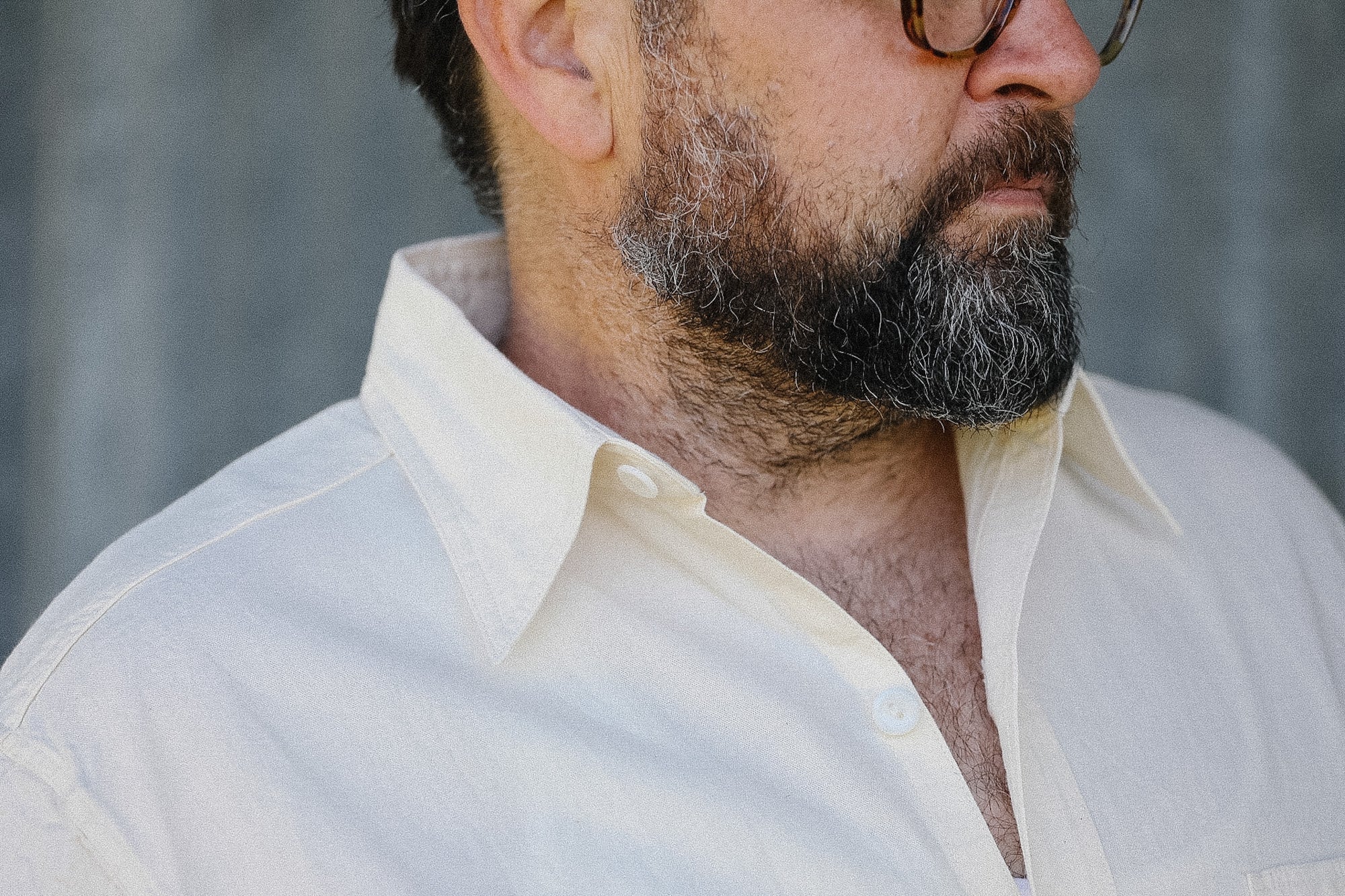 Man wearing a light-colored shirt with a blurred background