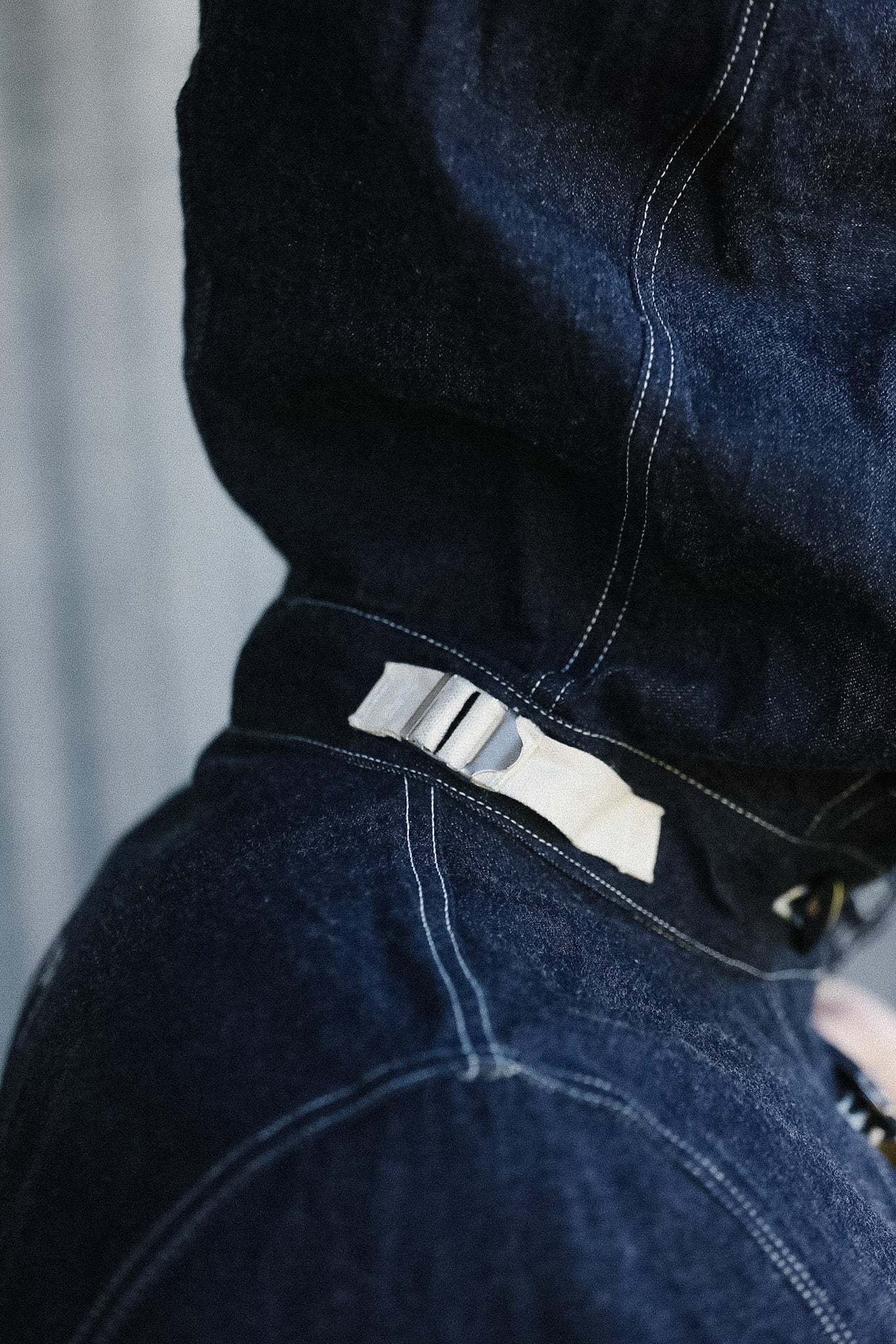 Close-up of a dark blue denim jacket with a brand label on a blurred background