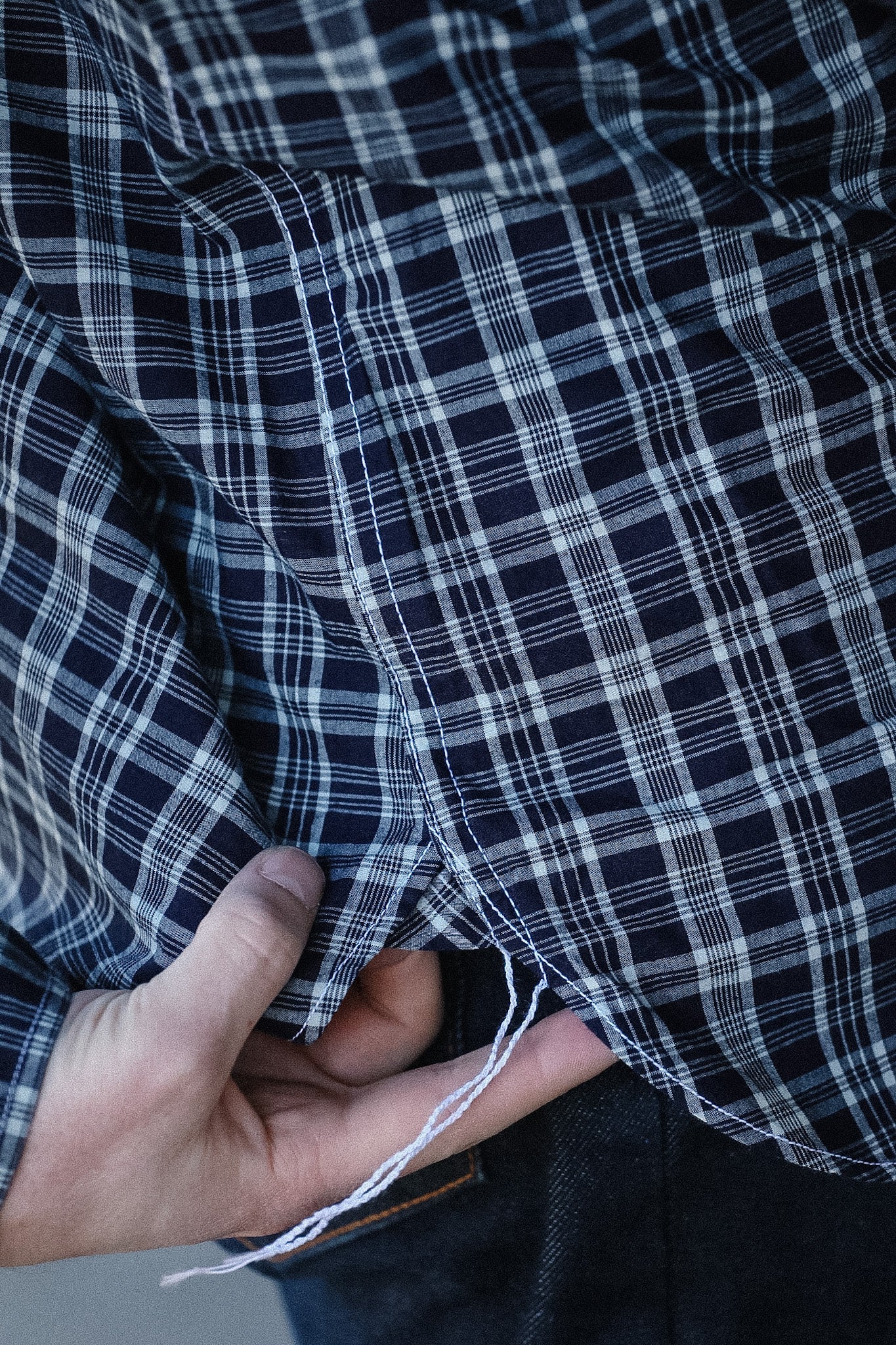 Close-up of black and white plaid fabric with a hand holding it.