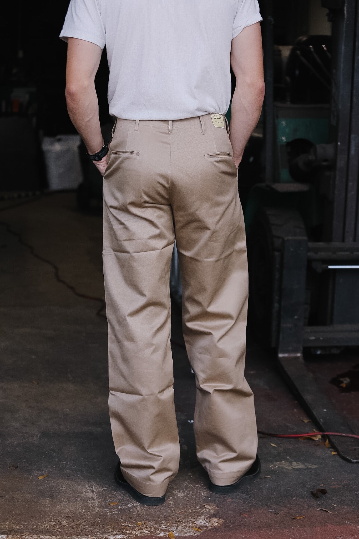 person wearing khaki pants on a dark background