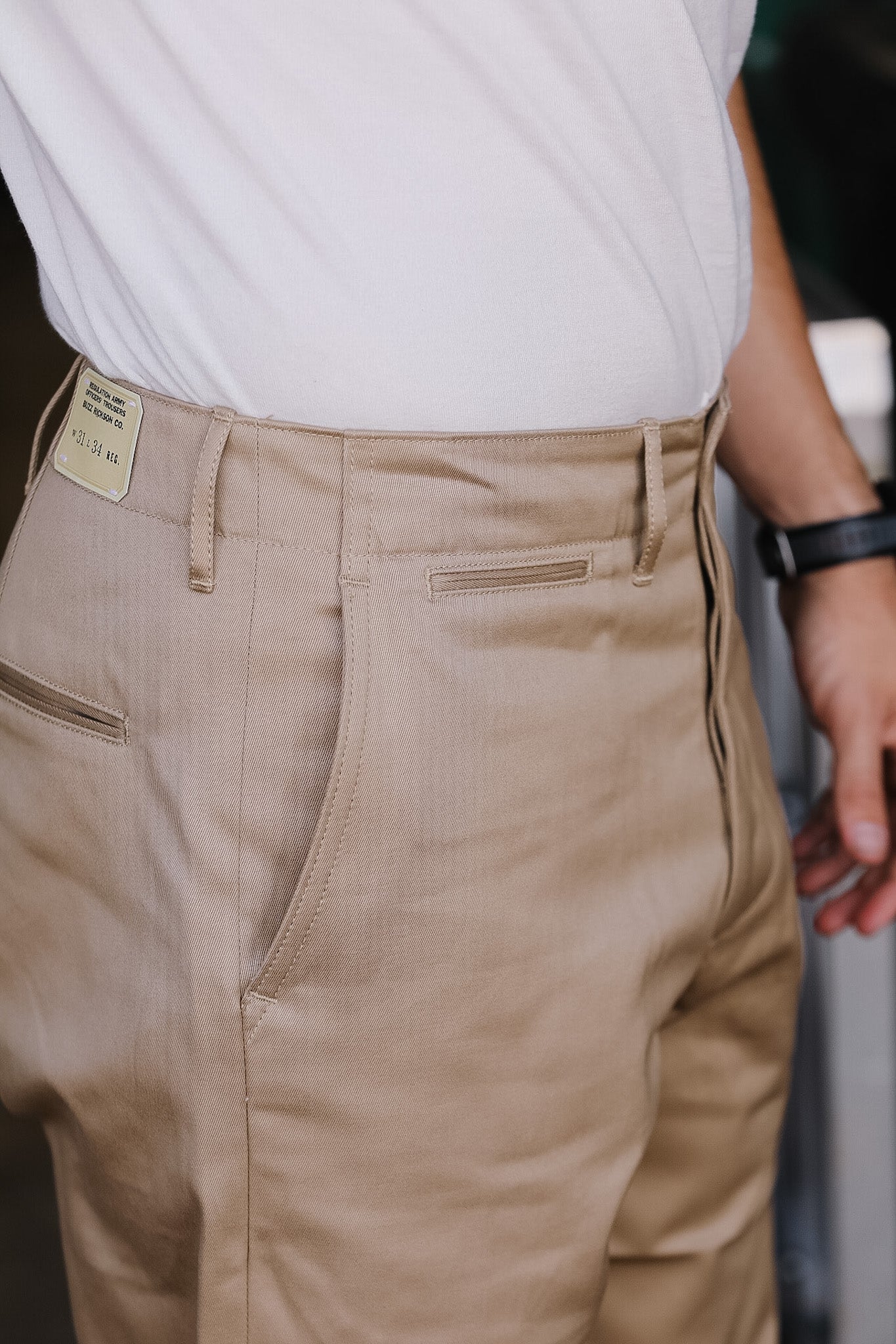 Close-up of beige pants with a white shirt and blurred background