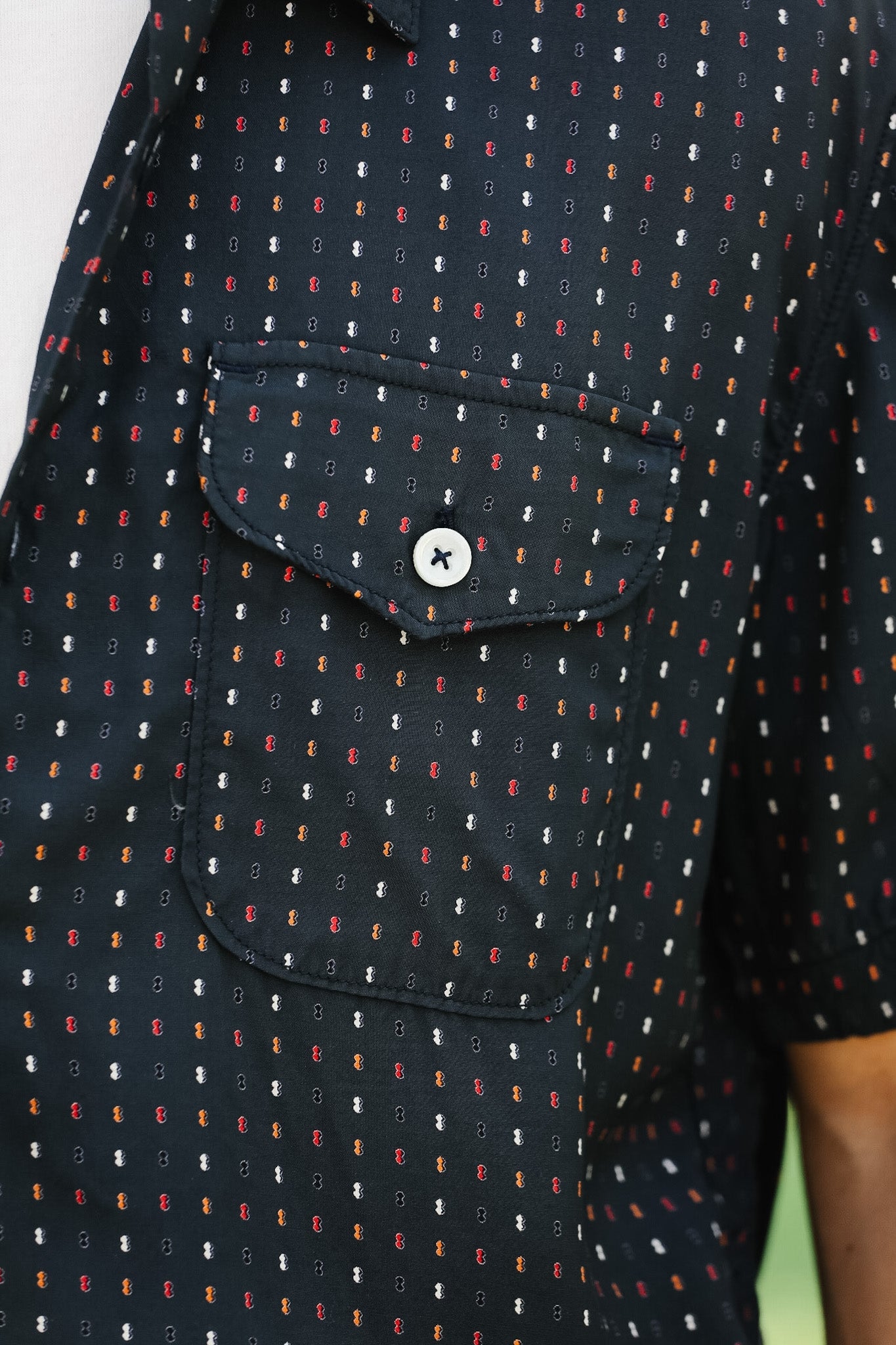 Close-up of a dark shirt with a pattern and two chest pockets.