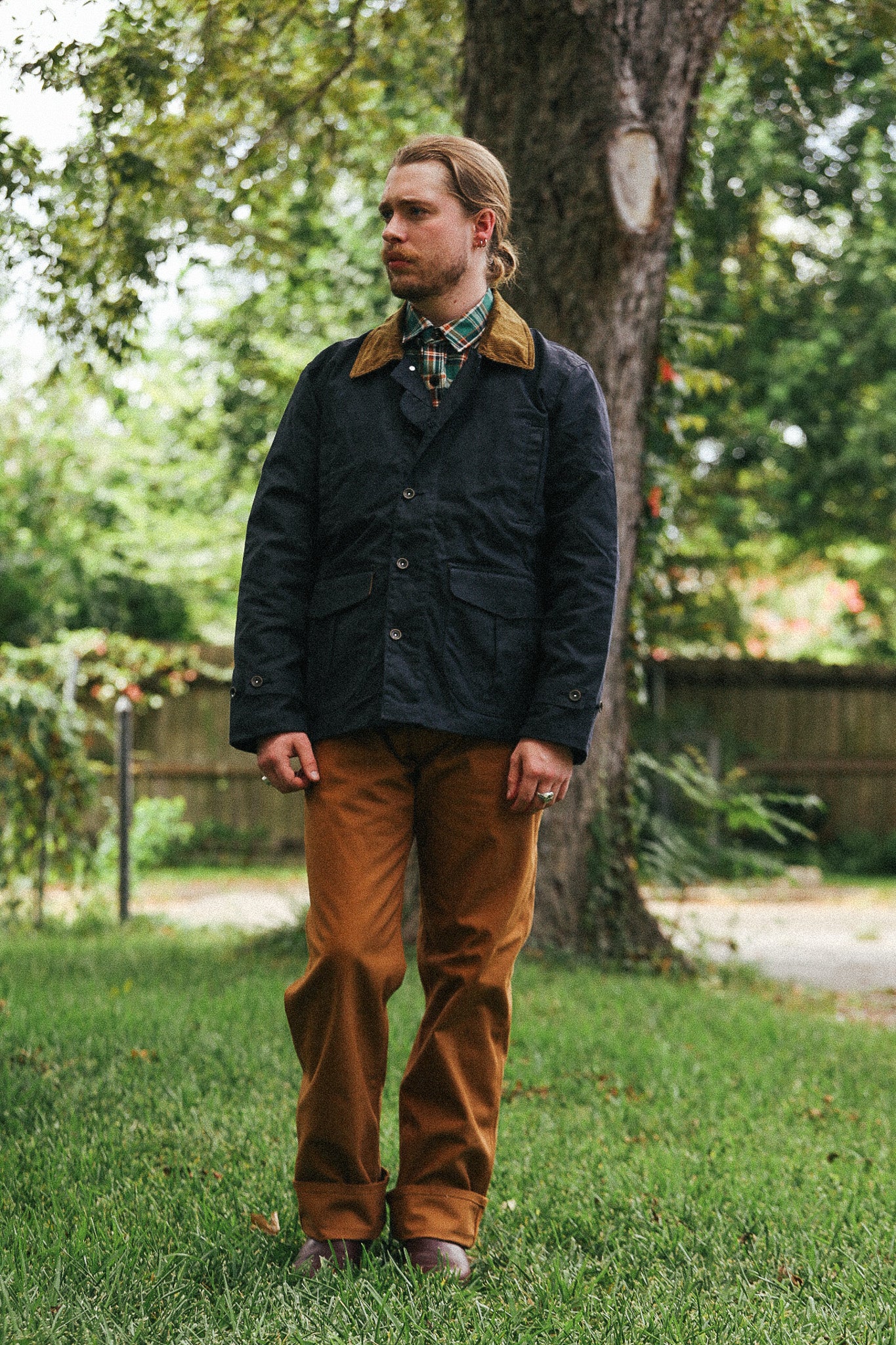 man with black jacket  against a green natural background