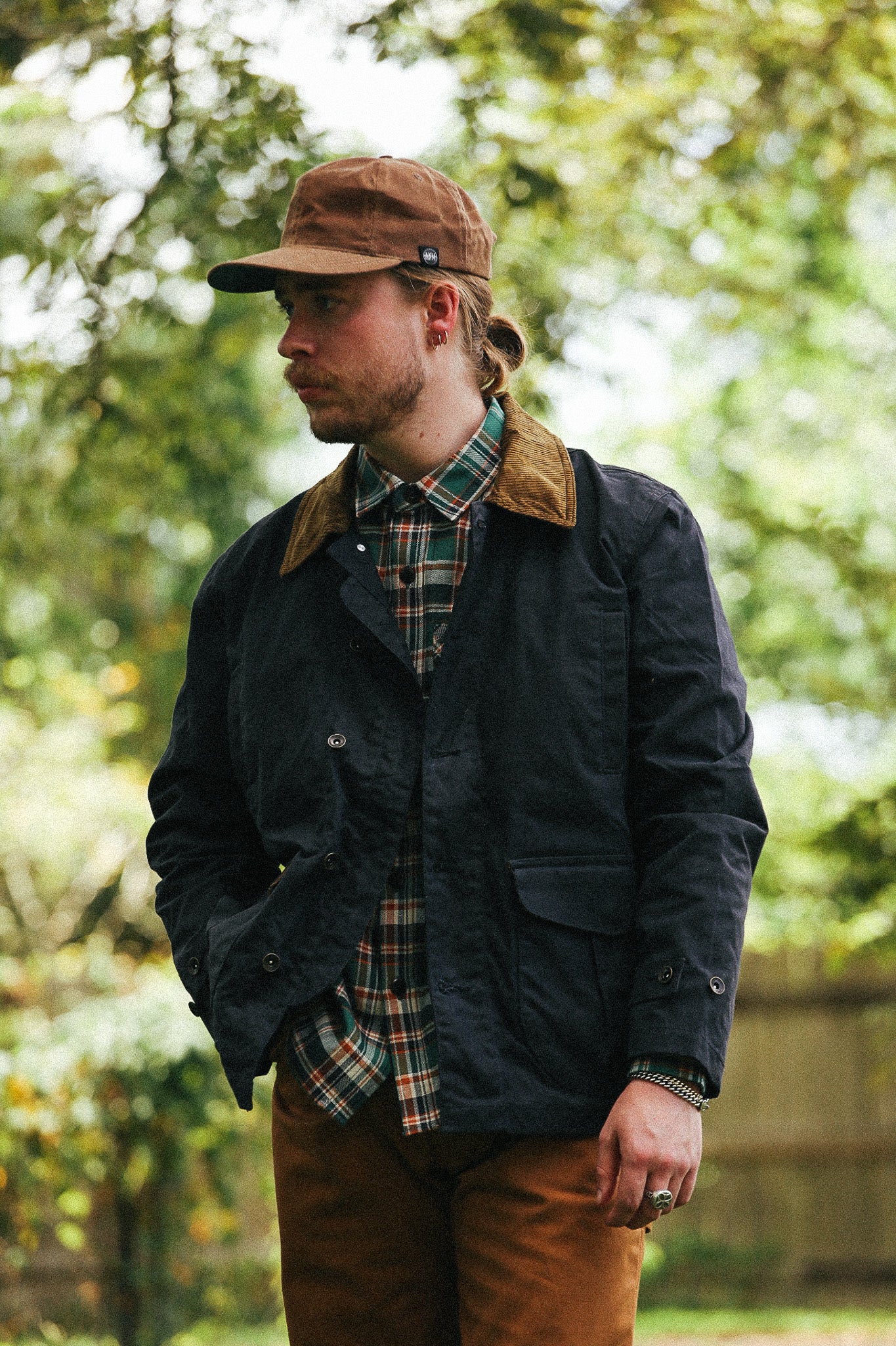 man with black jacket against a green natural background